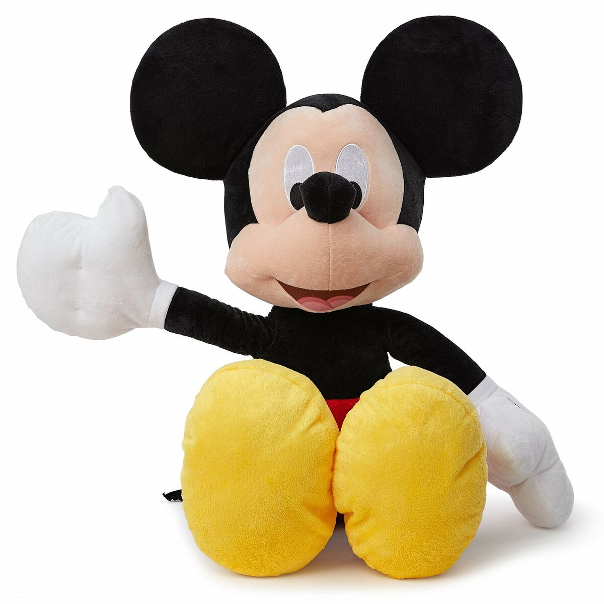 Peluche de Mickey Mouse, sentado, un brazo levantado. Guantes blancos, zapatos amarillos, fondo blanco.