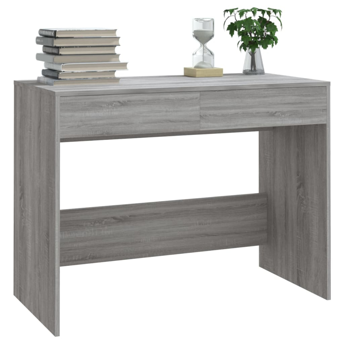 Ein grauer Holzschreibtisch mit Büchern, einem Sandtimer und einer kleinen Pflanze.