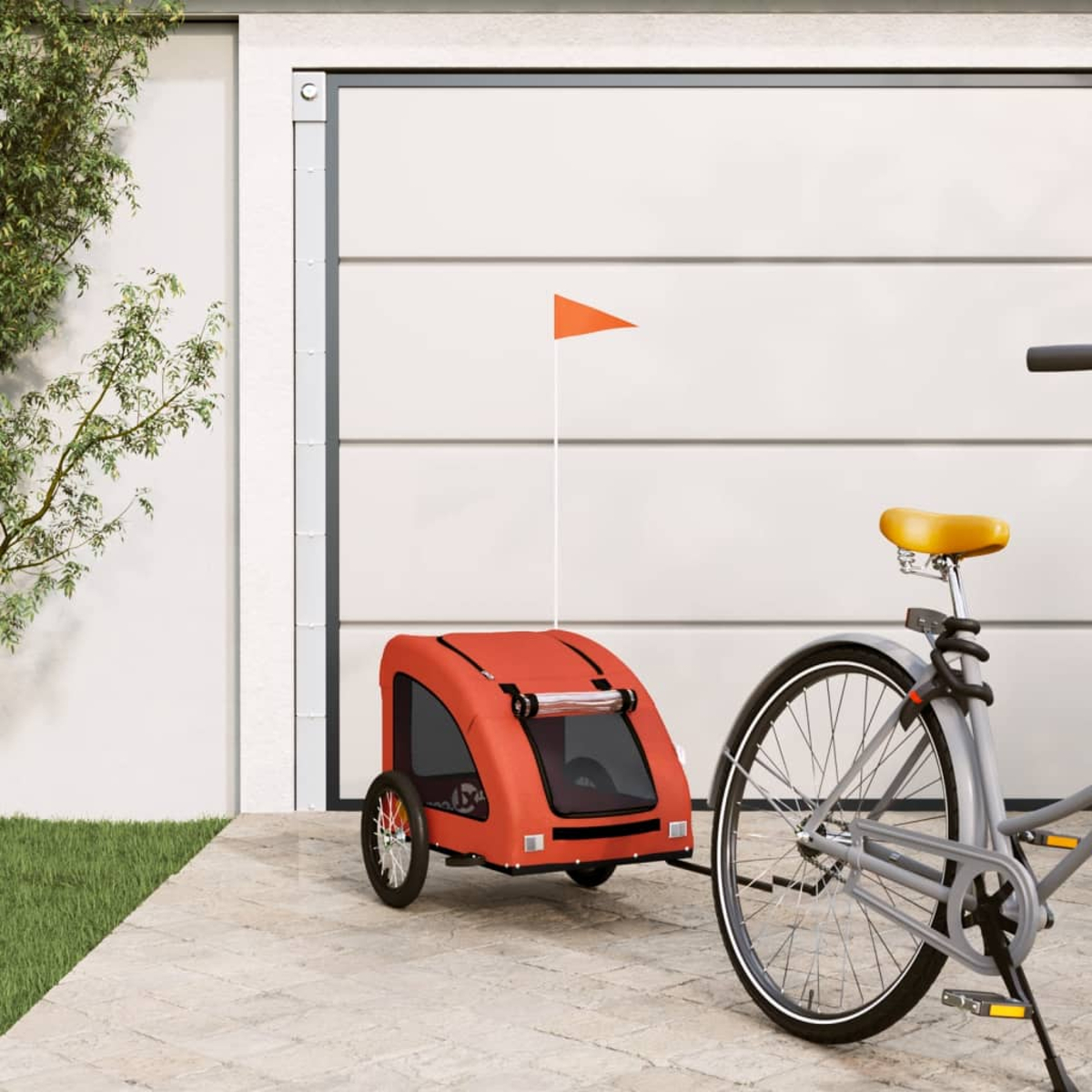 Roter Fahrradanhänger mit oranger Fahne, verbunden mit grauem Fahrrad.