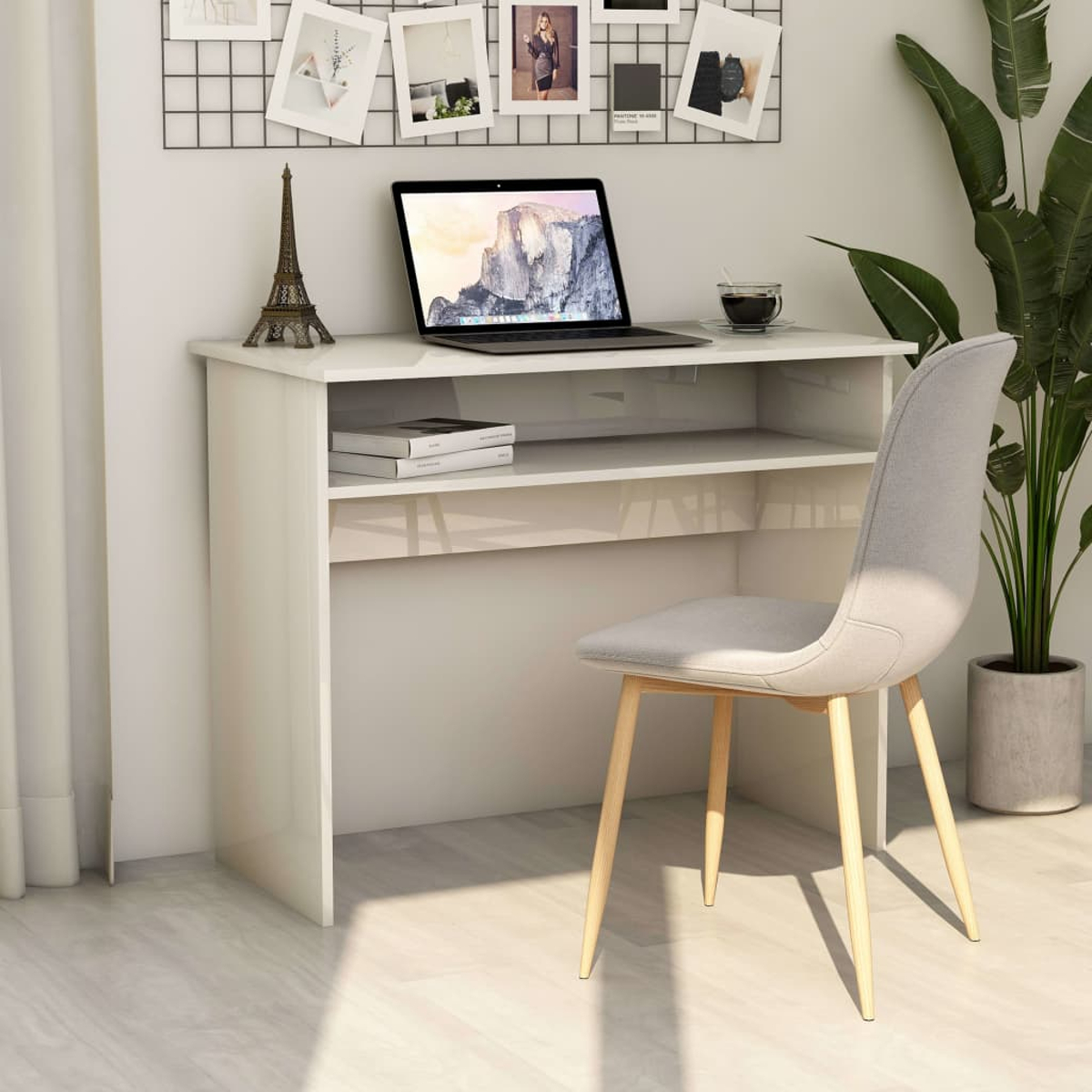 Weißer Schreibtisch mit Laptop, Büchern und Deko. Ein grauer Stuhl steht daneben. Hintergrund: Wand.