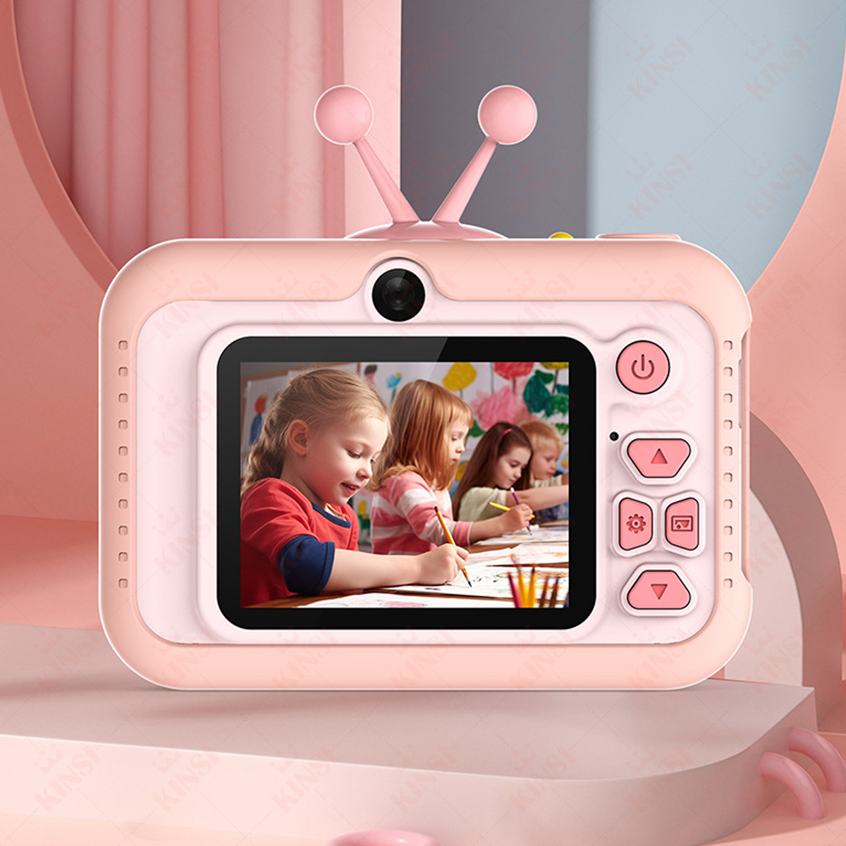Eine rosa Spielzeugkamera in TV-Form. Der Bildschirm zeigt 3 Kinder beim Zeichnen. Die Kamera hat Antennen und Knöpfe.