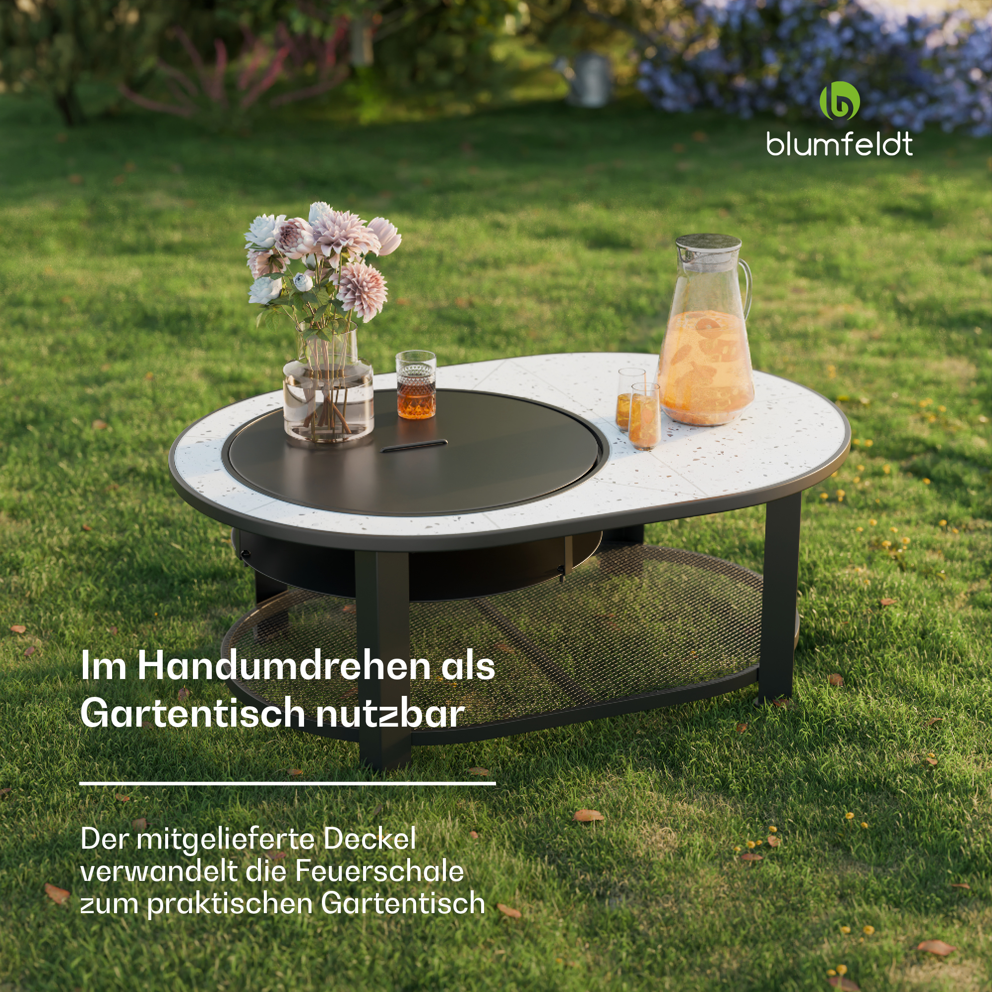 Ovaler Gartentisch mit Pflanzen, Getränken und Feuerstelle auf dem Rasen.