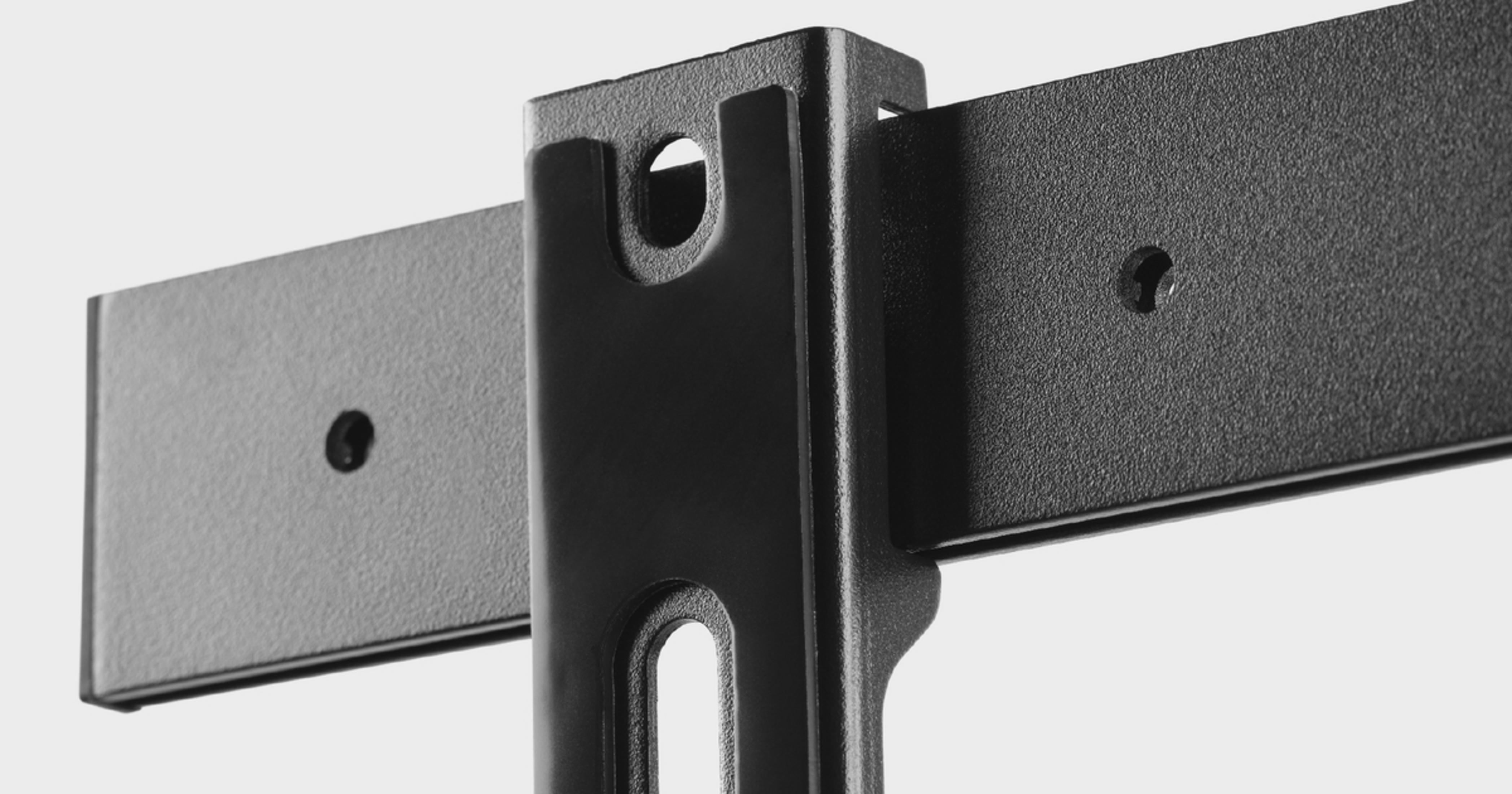 Close-up of a black and gray TV wall mount, with metal bars, on a gray background.