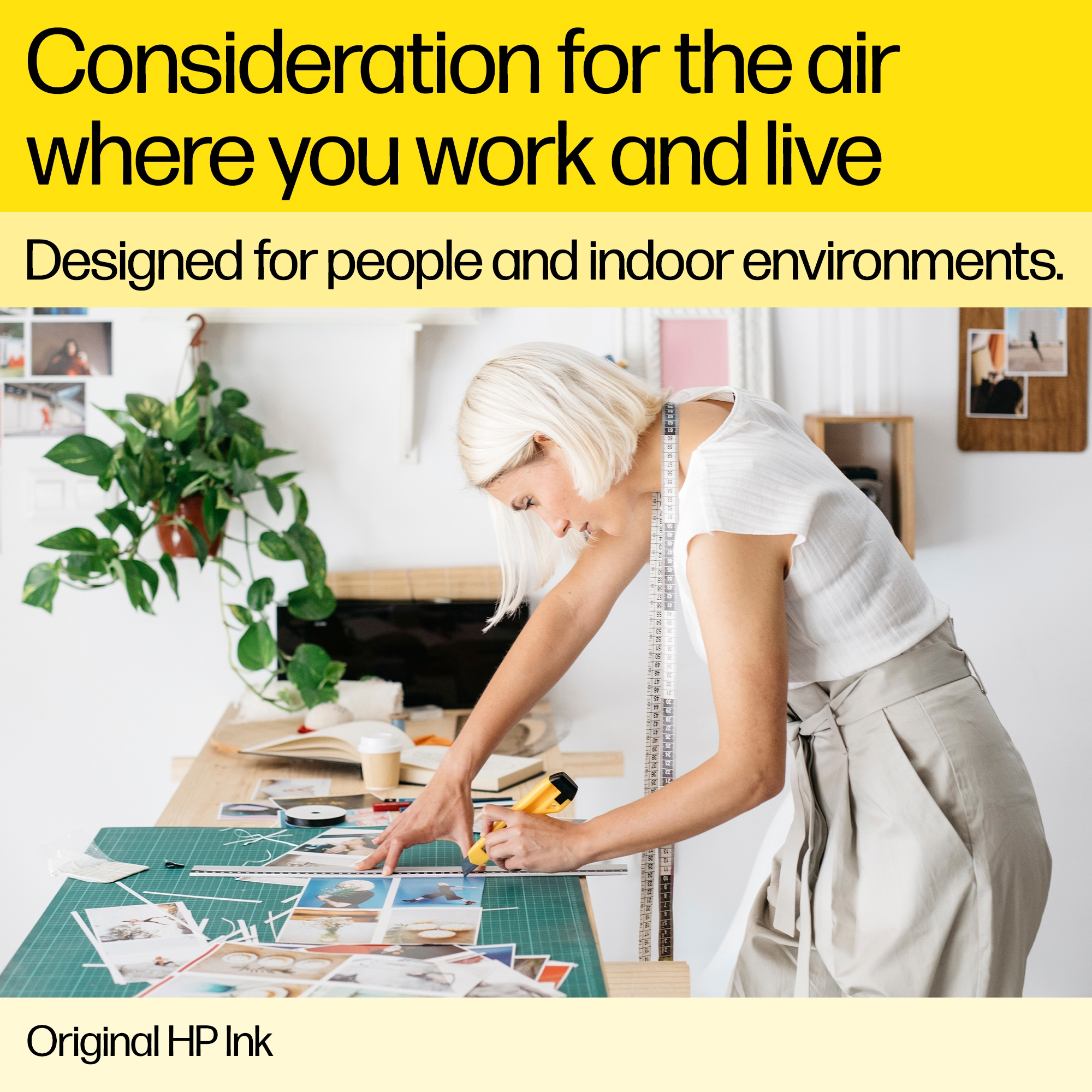 Kobieta pracująca przy biurku ze zdjęciami i roślinami. Tekst podkreśla dbałość o jakość powietrza w miejscu pracy.