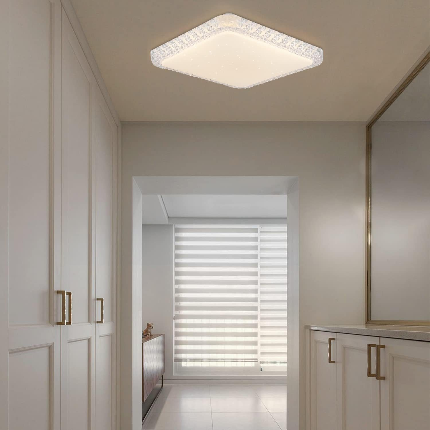 Un corridoio con pareti bianche, porte e una luce a soffitto. È visibile uno specchio.