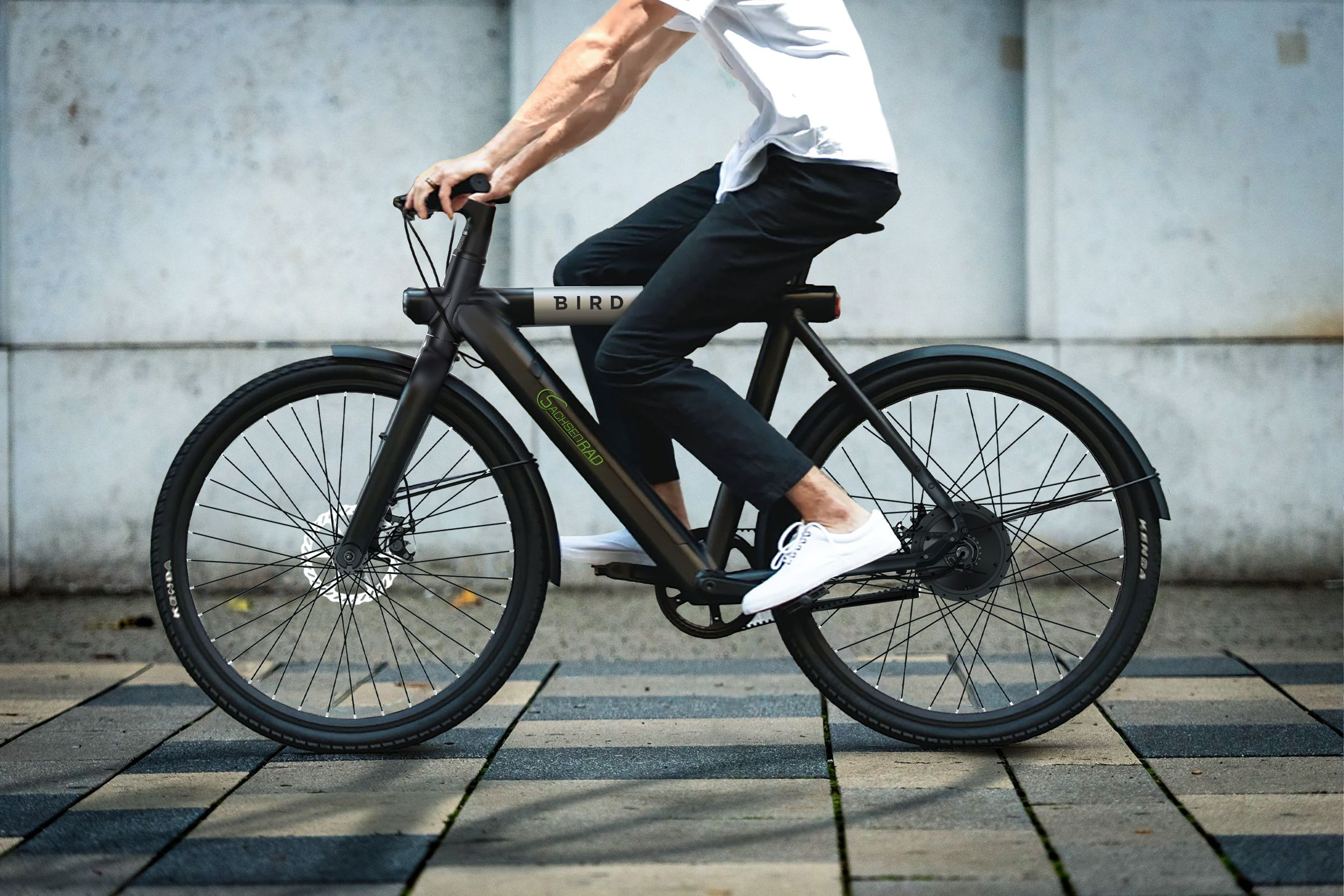 Eine Person fährt mit einem schwarzen Bird-Elektrofahrrad auf einer Stadtstraße.