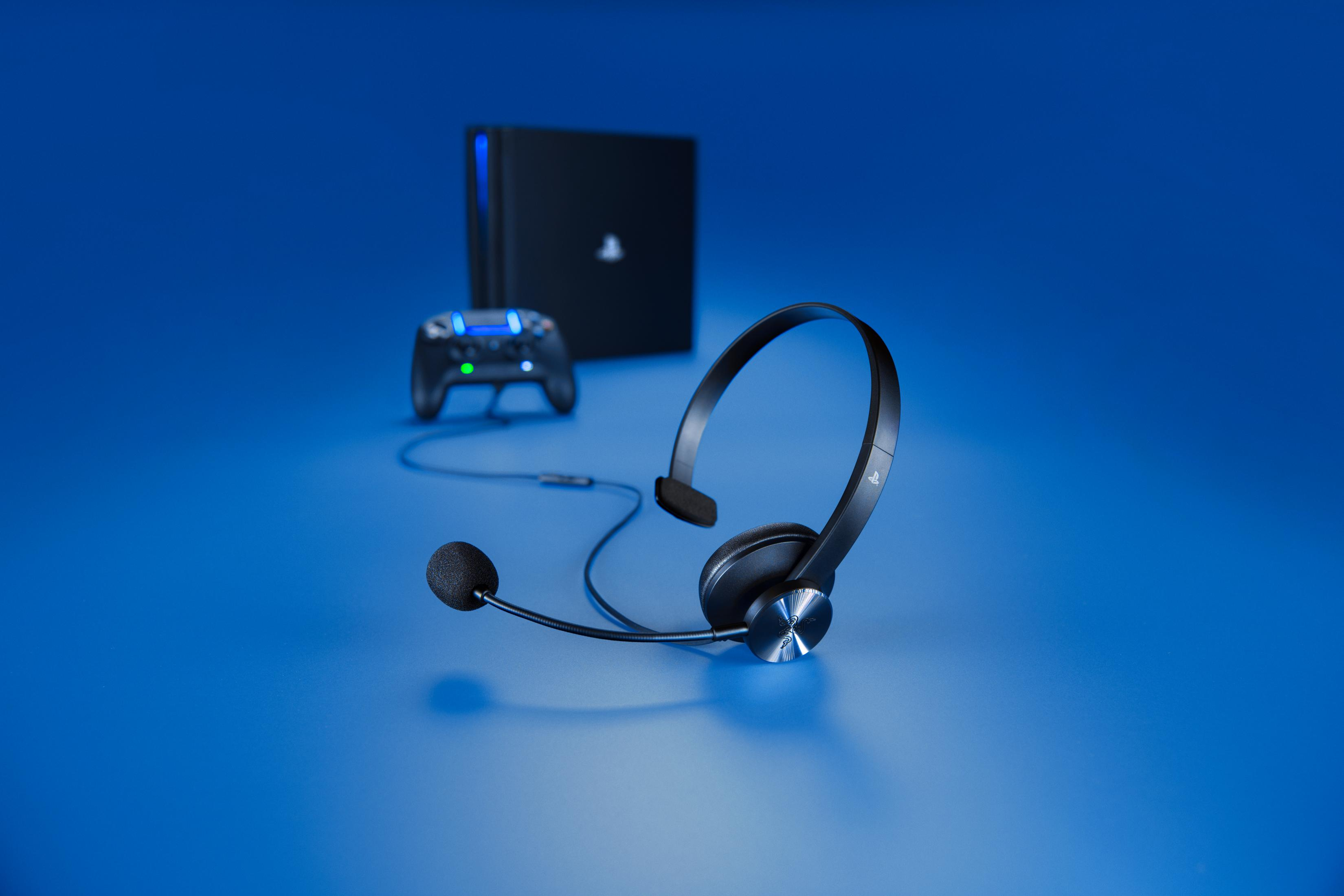 Czarny zestaw słuchawkowy z mikrofonem. Tło jest niebieskie, z konsolą do gier w tle.