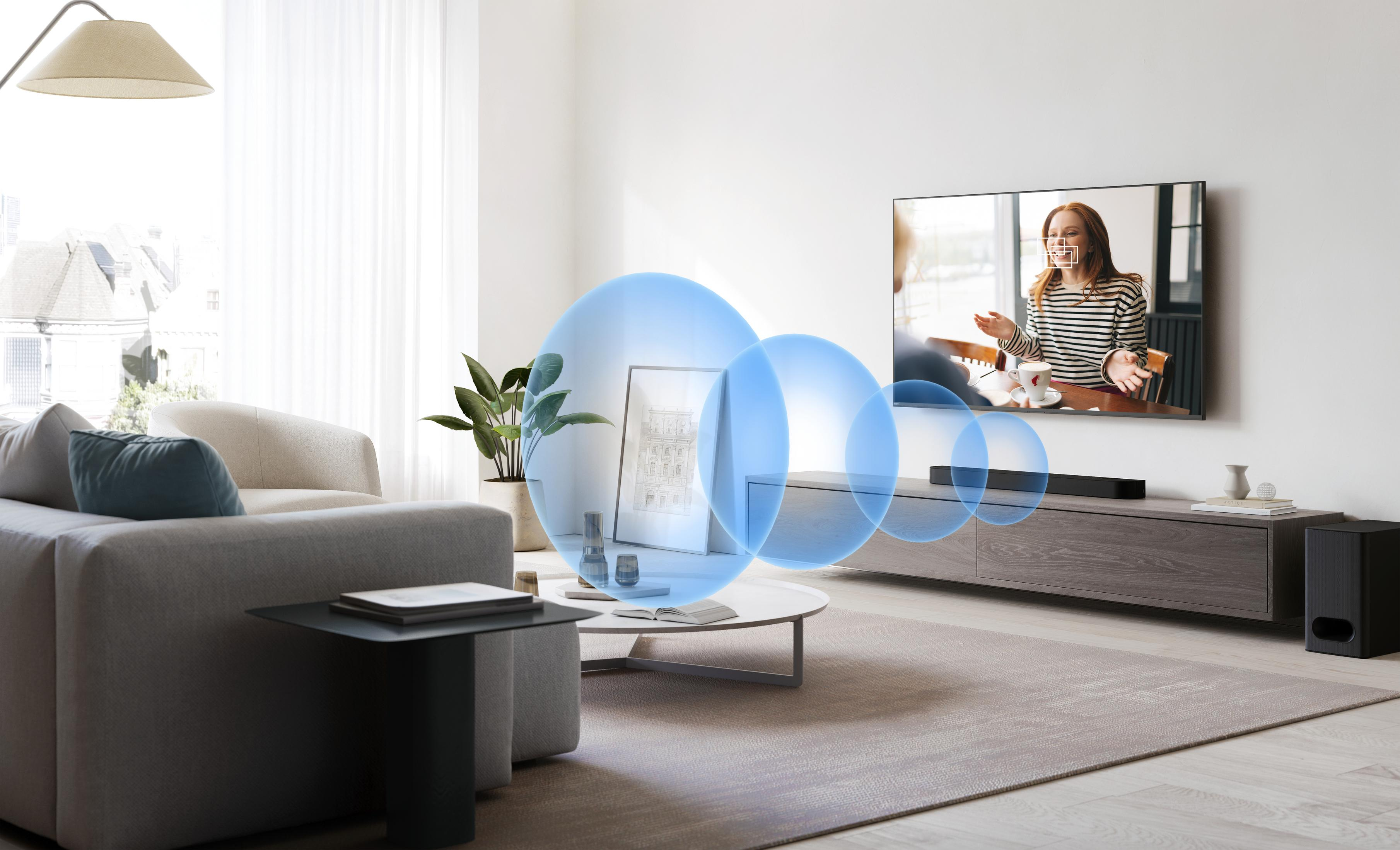 Soggiorno con TV, soundbar e subwoofer. Onde sonore blu si estendono dalla soundbar.