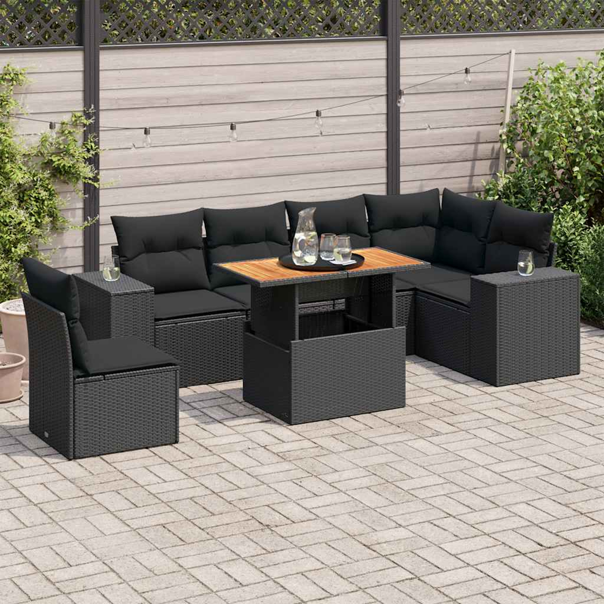 Set patio esterno in nero, con tavolo e cuscini. Luci e recinzione sullo sfondo.