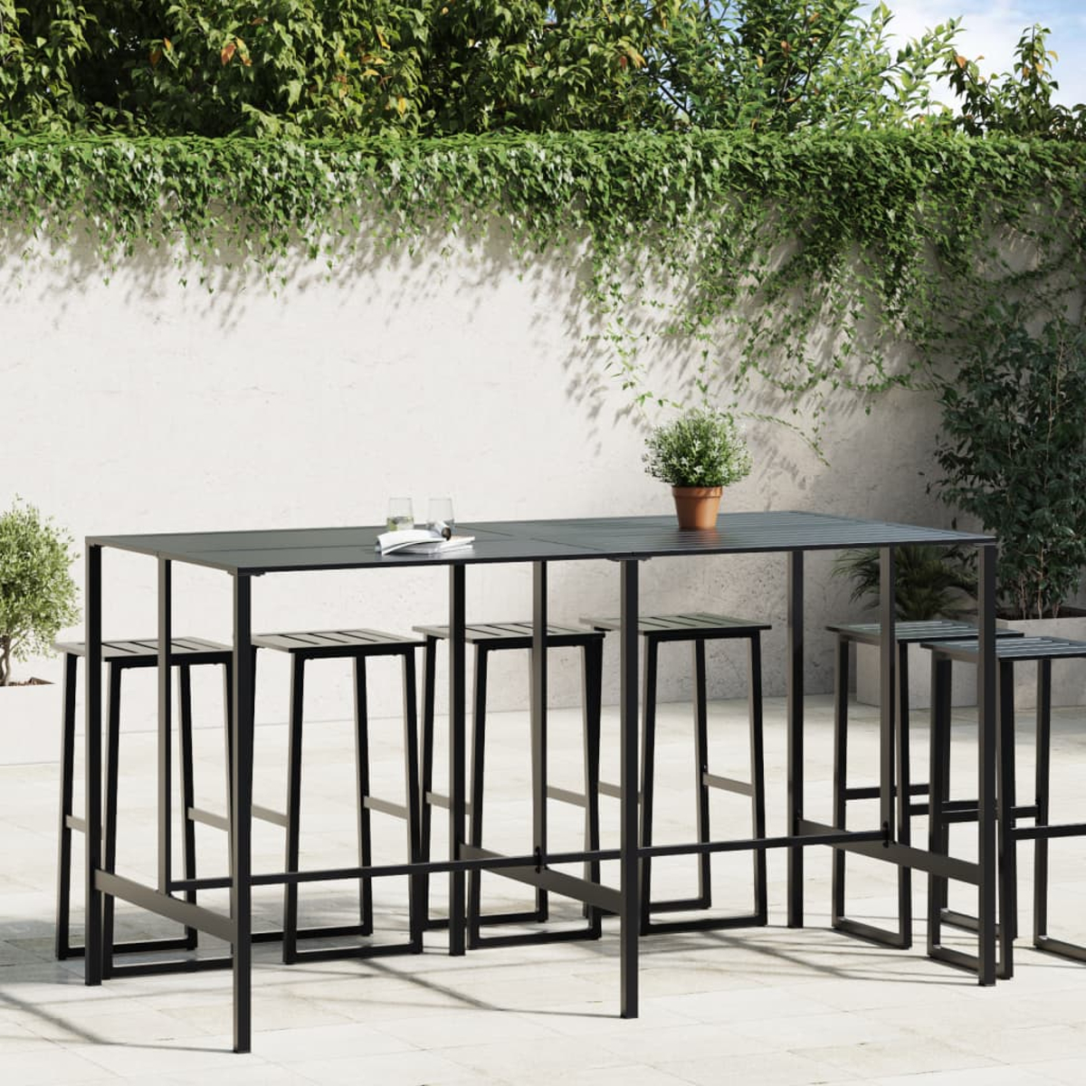 Schwarzer Bartisch im Freien mit mehreren Barhockern. Die Umgebung ist eine Terrasse mit weißer Wand.
