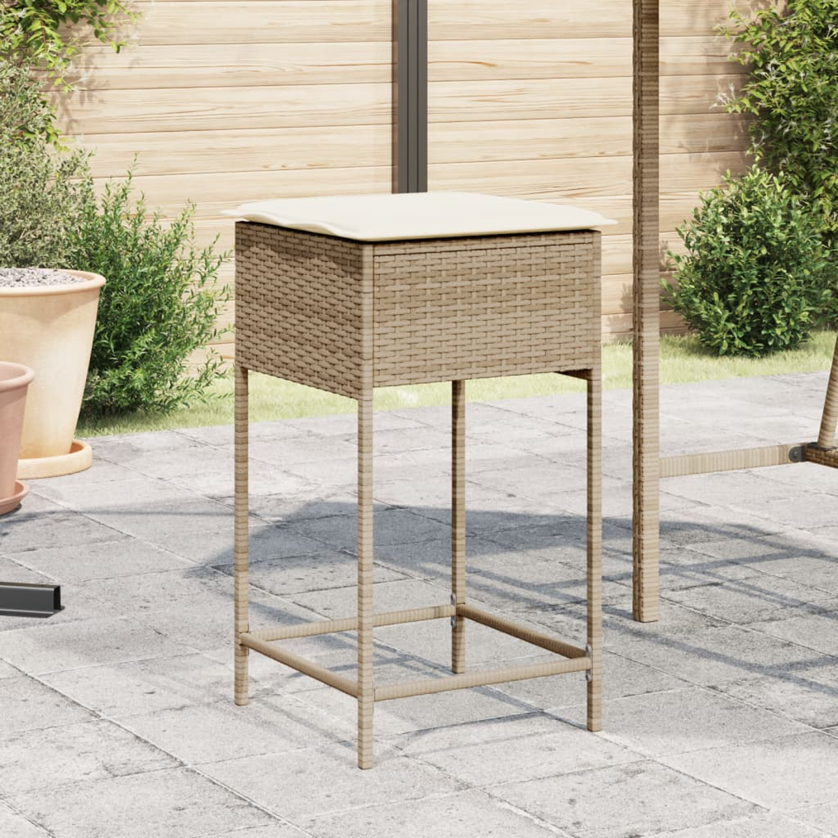 Ein Barhocker im Korb-Stil für den Außenbereich mit einem Kissen oben. Er steht auf einer gepflasterten Terrasse.