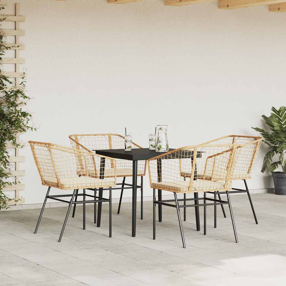 Essgruppe im Freien mit vier Stühlen und einem Tisch. Die Stühle sind gewebt, der Tisch ist schwarz.