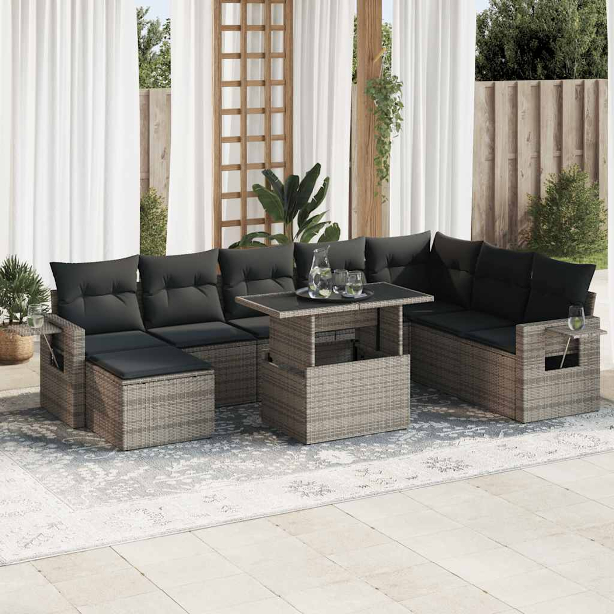 Graues Outdoor-Wicker-Sofagarnitur mit schwarzen Kissen und einem Tisch auf der Terrasse.