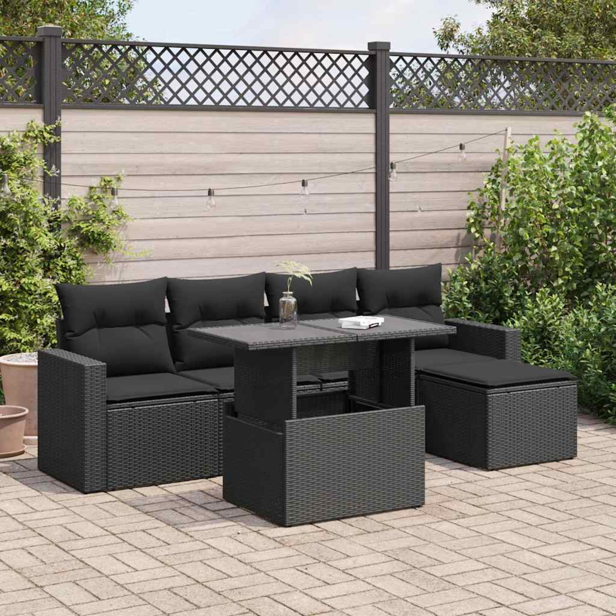 Schwarzes Gartenmöbel-Set auf einer Terrasse, einschließlich Sofa, Ottomane und Tisch.
