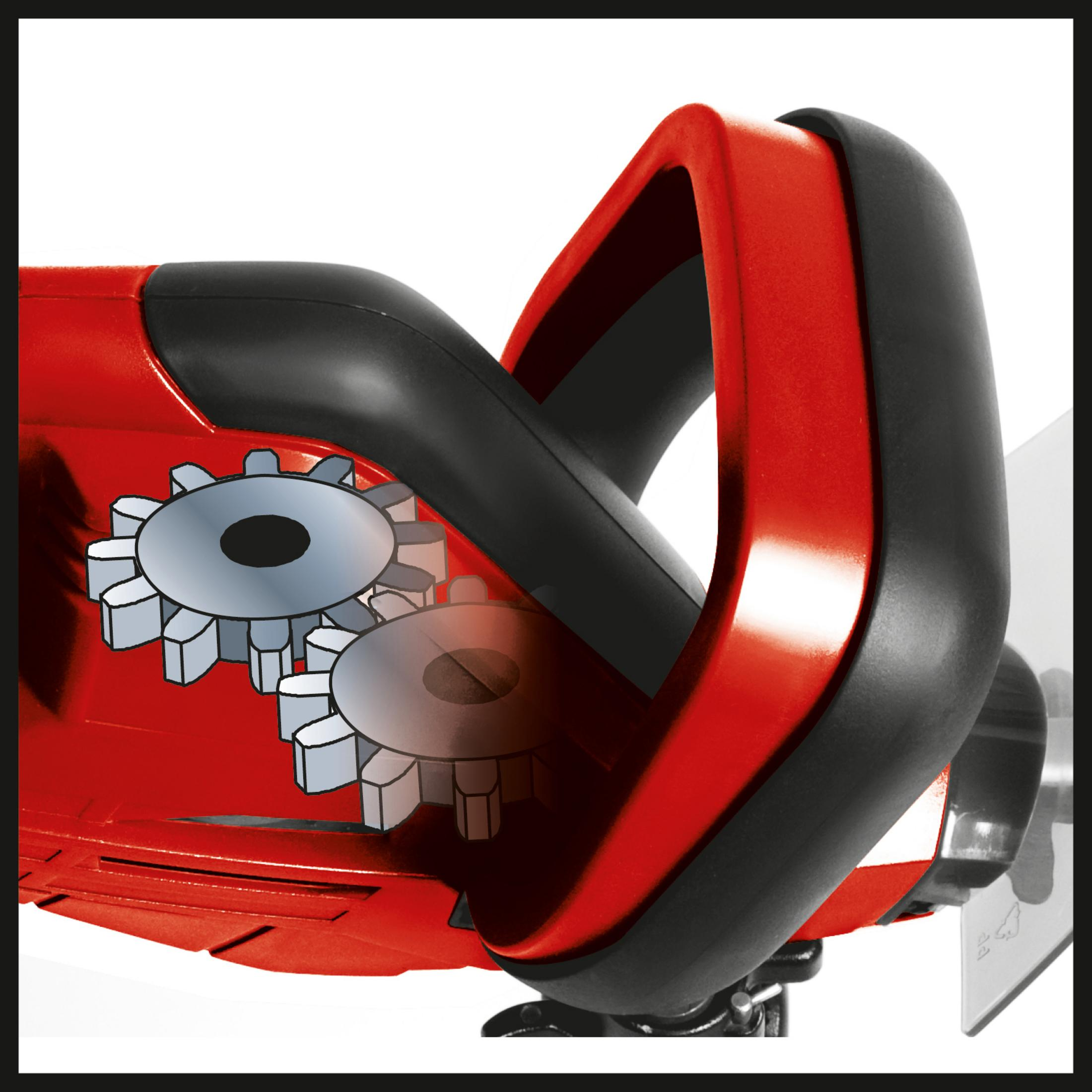 Zbliżenie czerwono-czarnej nożycy do żywopłotu. Pokazano koła zębate wewnątrz.