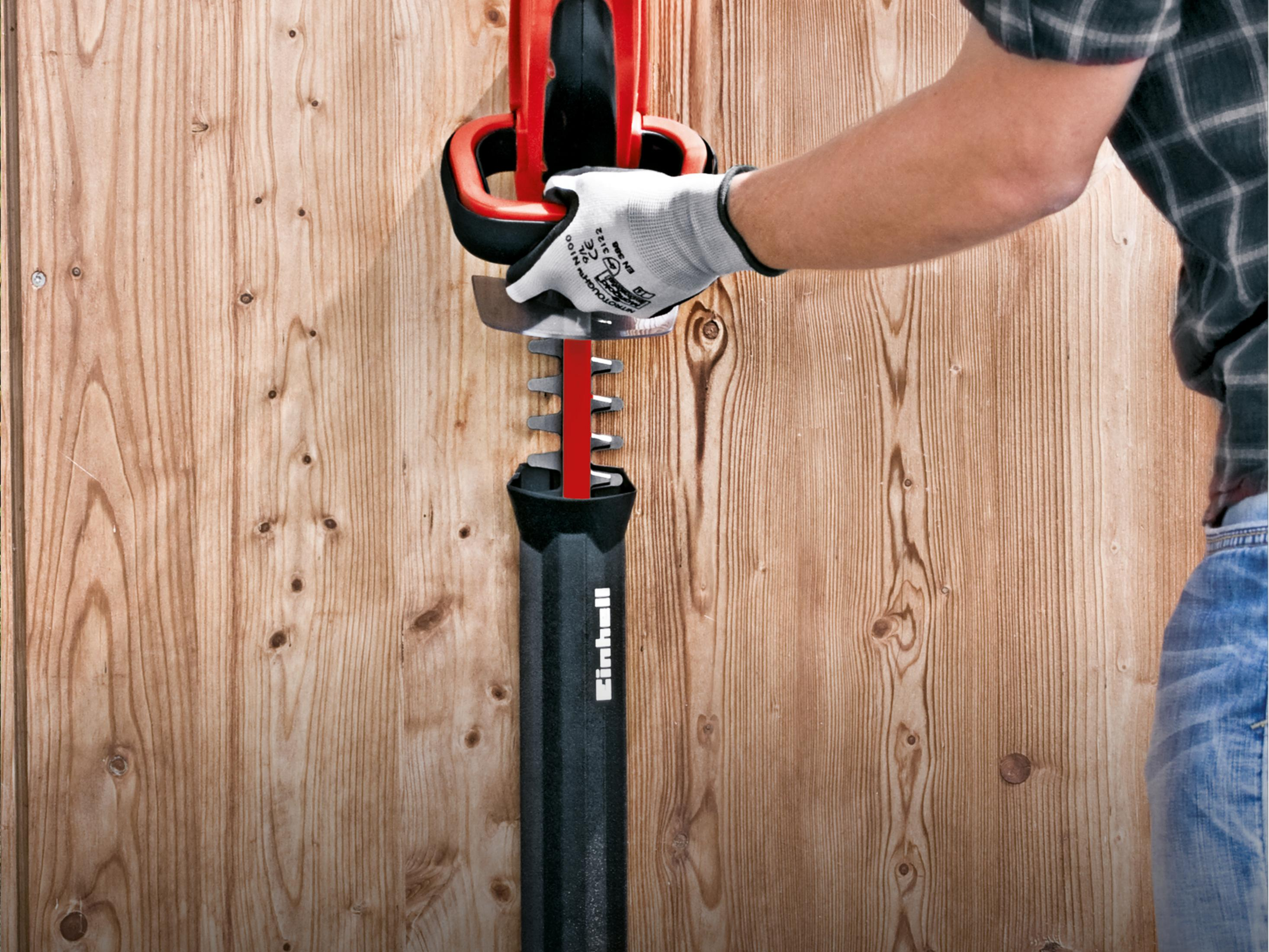 Osoba używająca nożyc do żywopłotu, zbliżenie, drewniane tło.