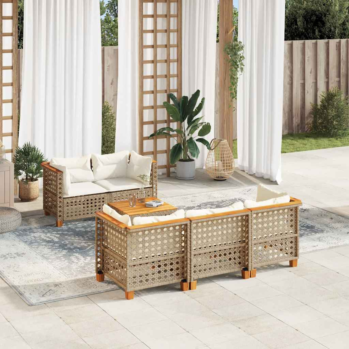 Set da patio all'aperto con tende bianche, tappeto e piante. Mobili in vimini e tavolo in legno.