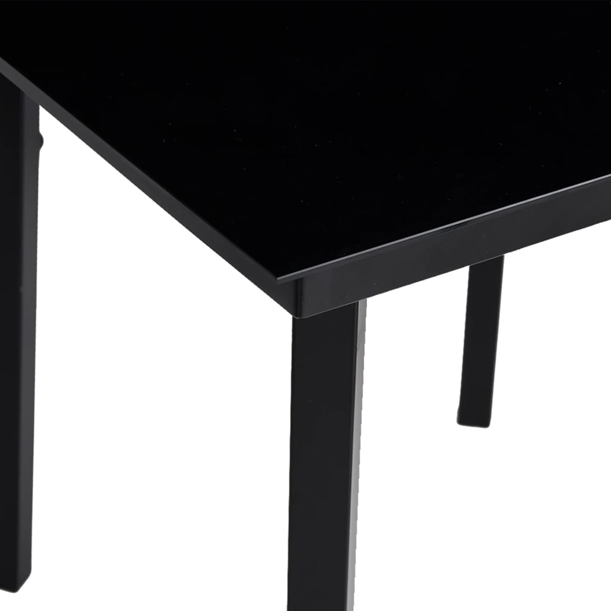 Angolo di tavolo nero lucido su sfondo bianco. Sono visibili le gambe e l'angolo del tavolo.