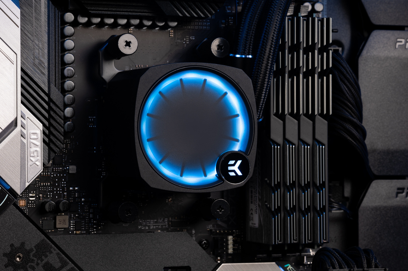 Un primo piano dei componenti interni di un computer, incluso un blocco di raffreddamento a liquido con un anello LED blu.