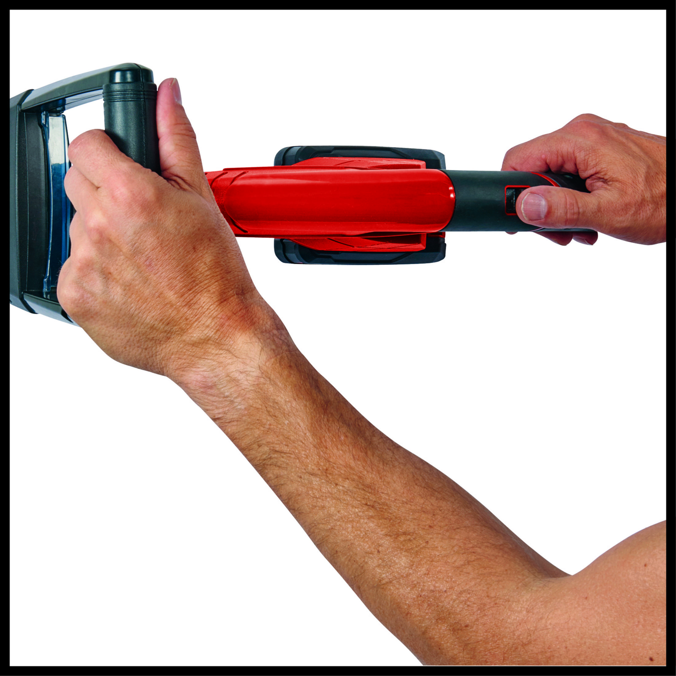 Zwei Hände halten einen rot-schwarzen Rasentrimmer. Der Trimmer ist abgewinkelt, mit weißem Hintergrund.
