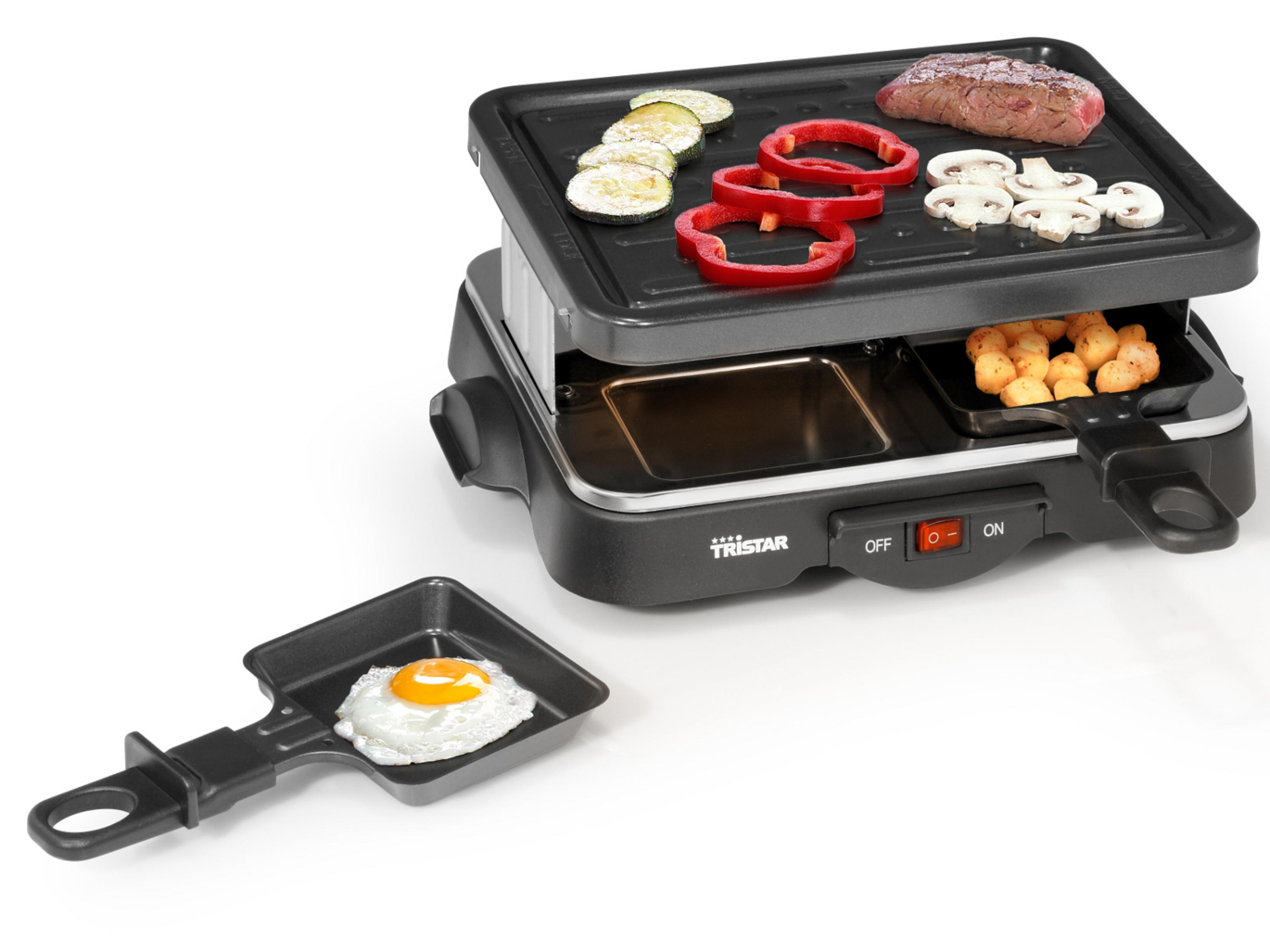 Grill do raclette ze składnikami. Warzywa i mięso. Jajko sadzone na patelni.