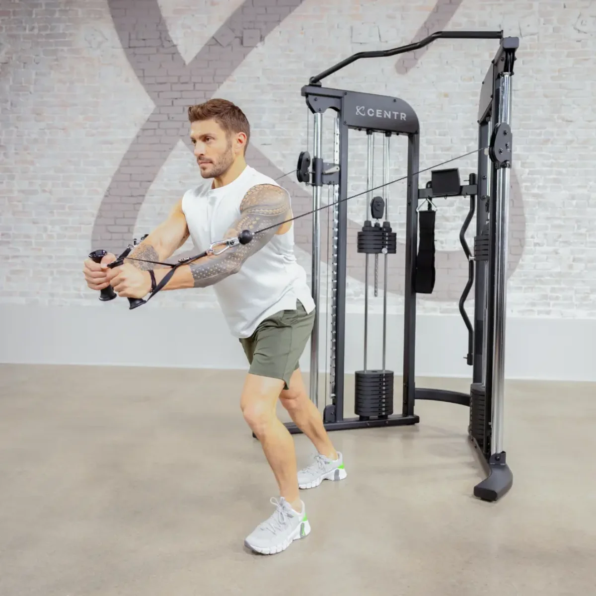 Homme utilisant une machine à câbles dans une salle de sport, soulevant des poids.