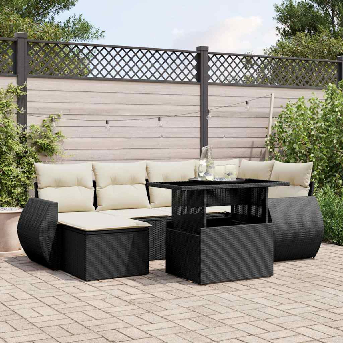 Schwarzes Outdoor-Sofagarnitur mit beigen Kissen und einem passenden Tisch auf einer Backstein-Terrasse.