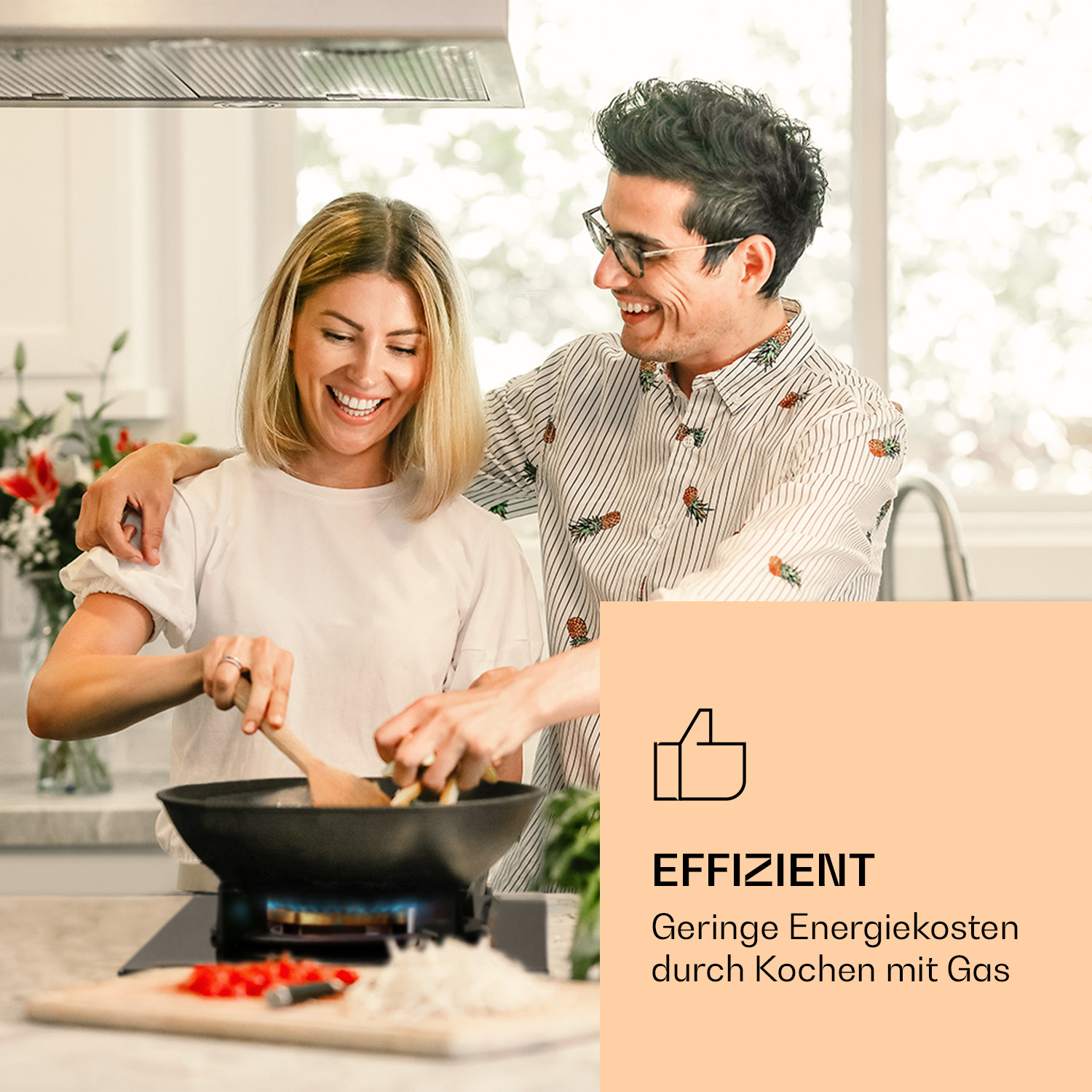 Coppia che cucina in cucina, sorridente, con un fornello a gas.