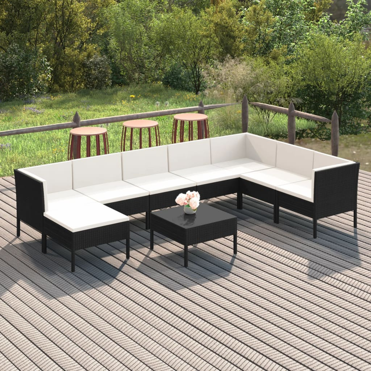 Terrassenmöbel-Set: schwarze Korbmöbel mit weißen Kissen, auf Holzterrasse.