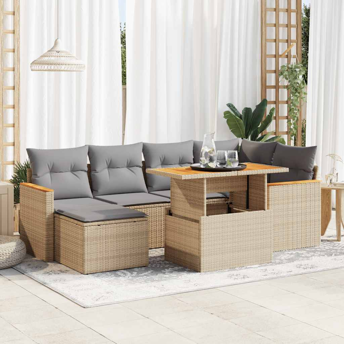 Set di divani in vimini per esterni con cuscini grigi e tavolo elevabile. Include una tenda bianca.
