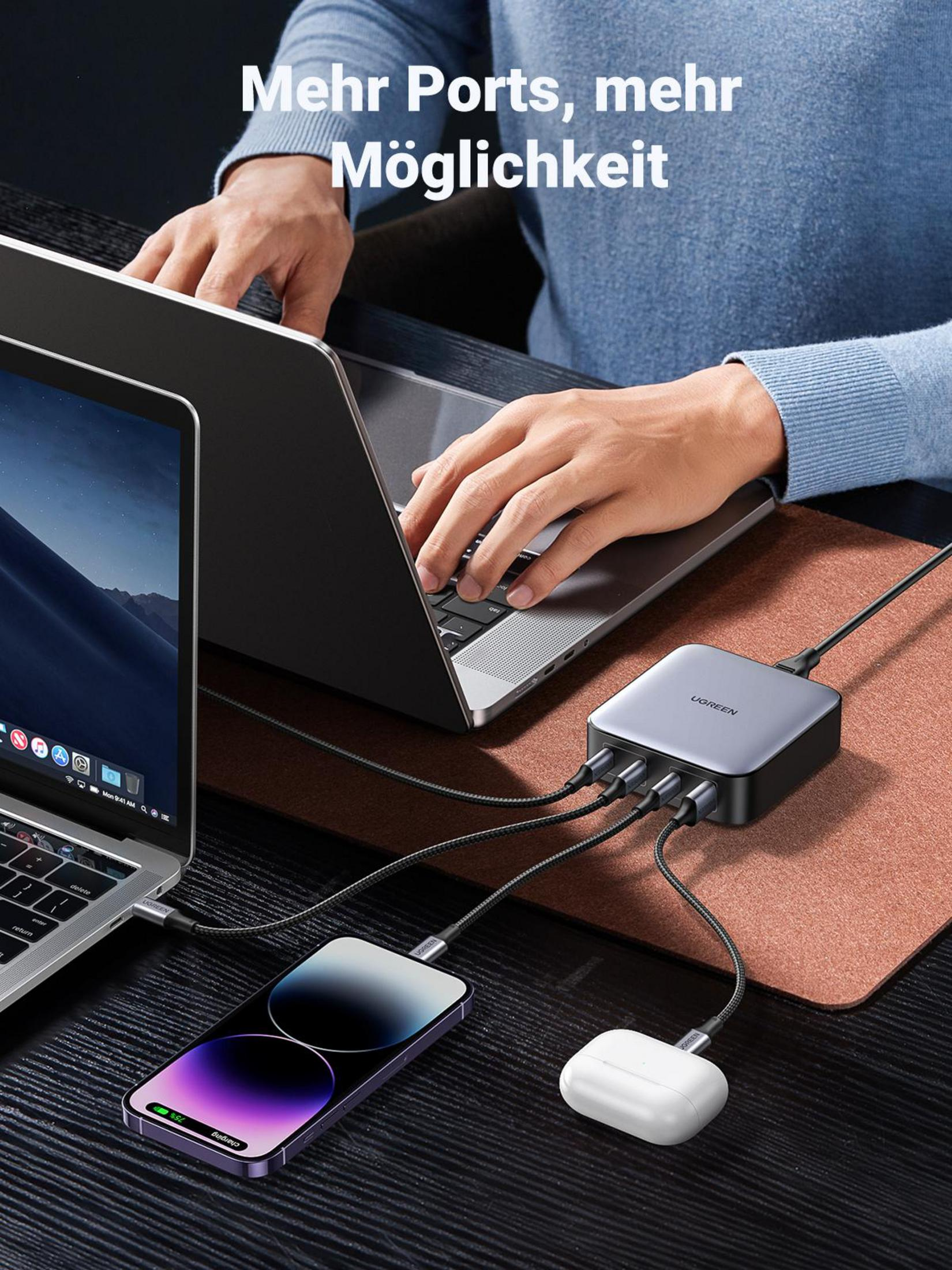 Persona che usa un laptop, carica più dispositivi con un hub USB UGREEN.