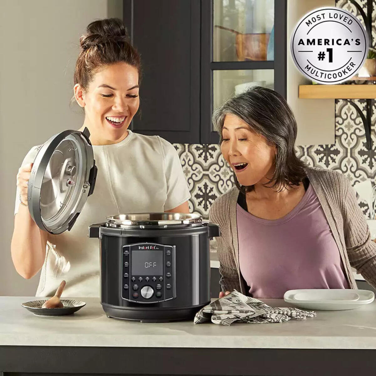 Twee vrouwen bekijken een Instant Pot Pro. Keukenomgeving met wit aanrecht.