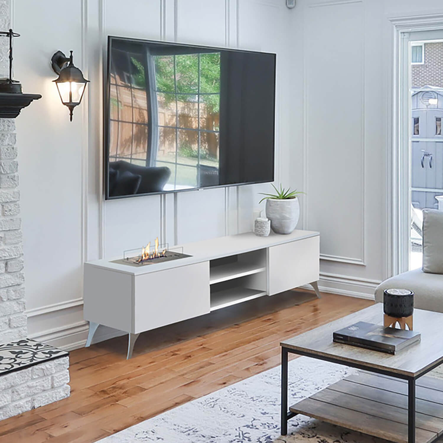 Woonkamer met tv, open haard met vlammen en een witte kast. Een raam rechts.