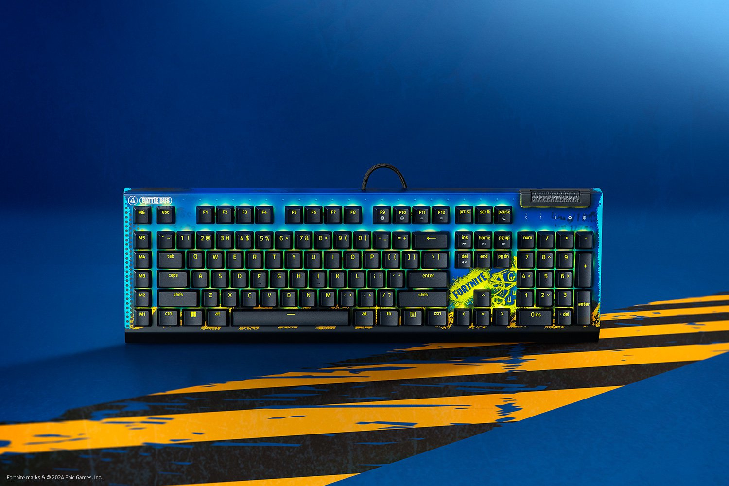 Tastiera blu con tasti verdi e gialli. Logo Fortnite sulla barra spaziatrice. Tasti neri.