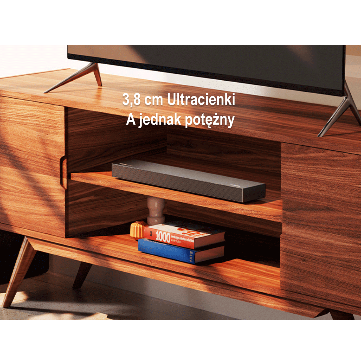 Soundbar umieszczony pod telewizorem na drewnianej szafce. Tekst wskazuje, że soundbar jest ultracienki, a jednocześnie mocny.