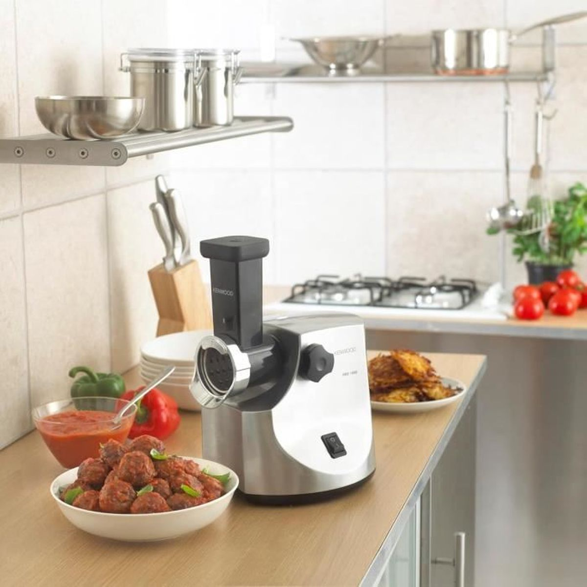 Maszynka do mięsa Kenwood na blacie kuchennym z klopsikami i innymi potrawami.