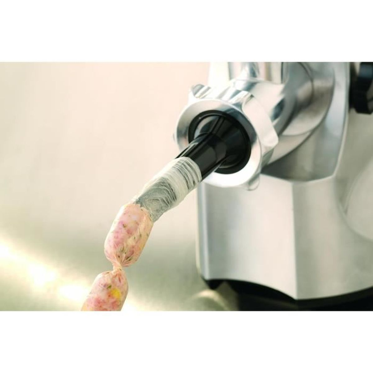 Zbliżenie mięsa wyciskane do osłonki kiełbasy przez maszynkę do mięsa.