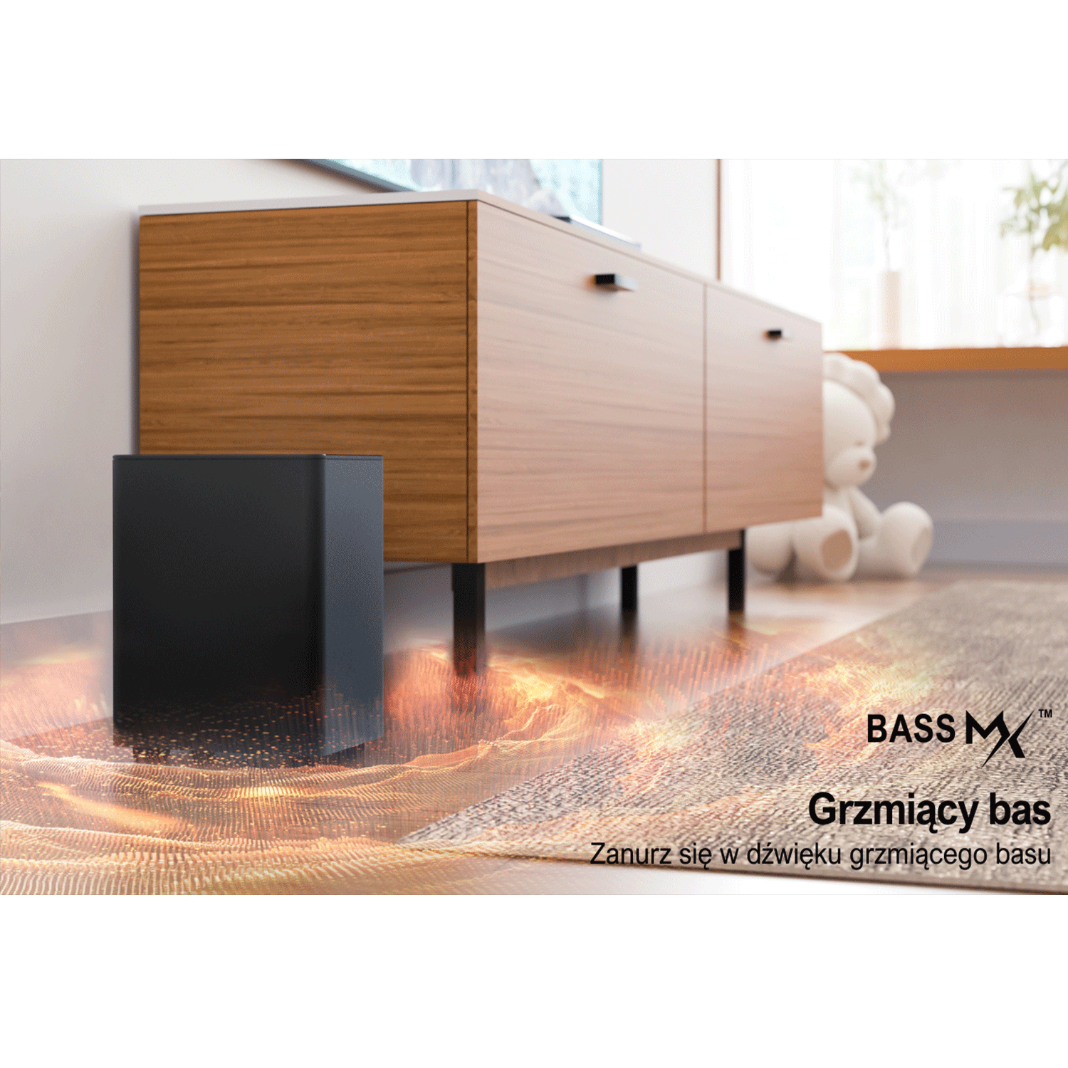 Czarny subwoofer na podłodze, drewniana szafka, biały miś w tle. Tekst: Bass MX. Grzmiący bas.