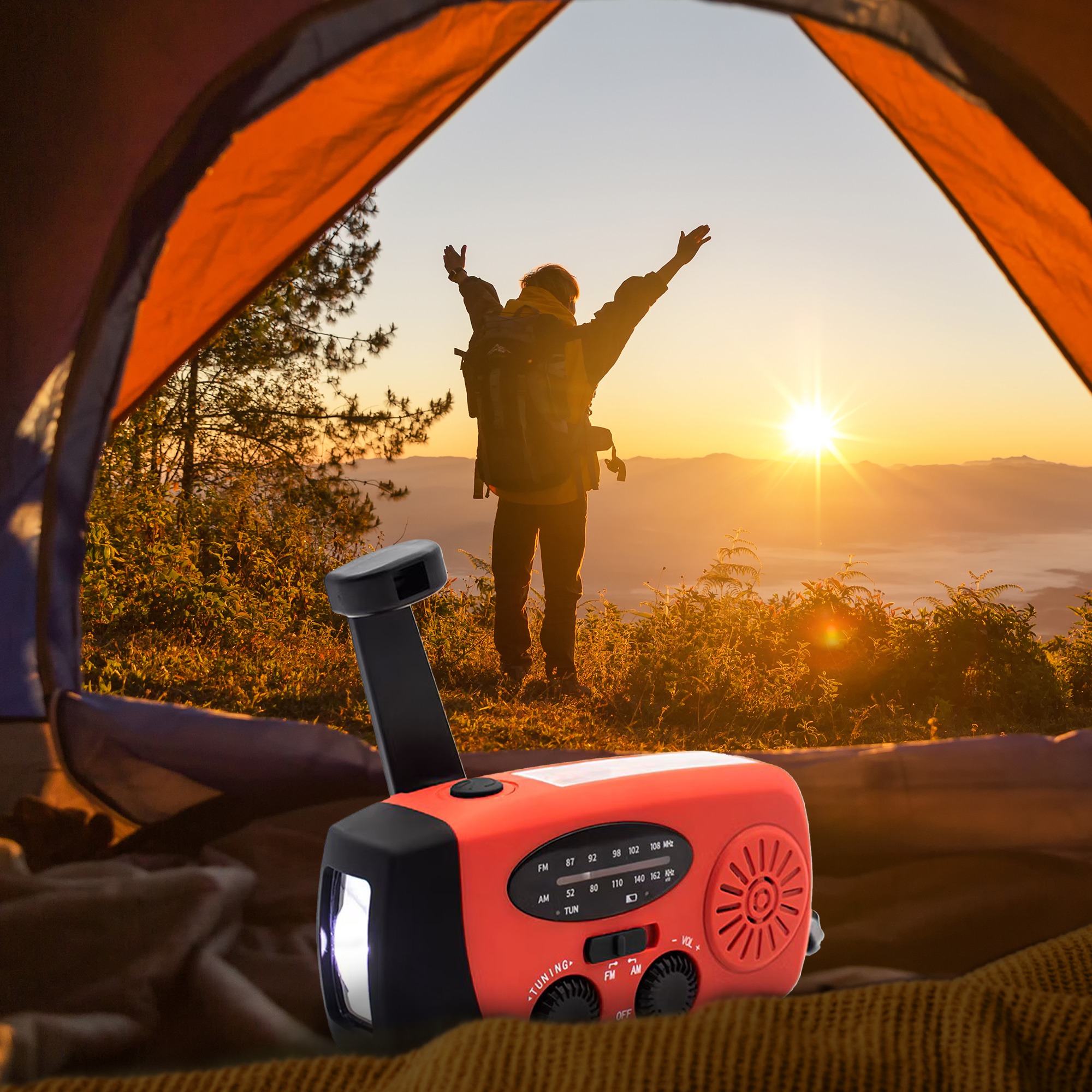 Persoon staat in tentopening, heft armen naar zonsondergang. Rode radio met handslinger.