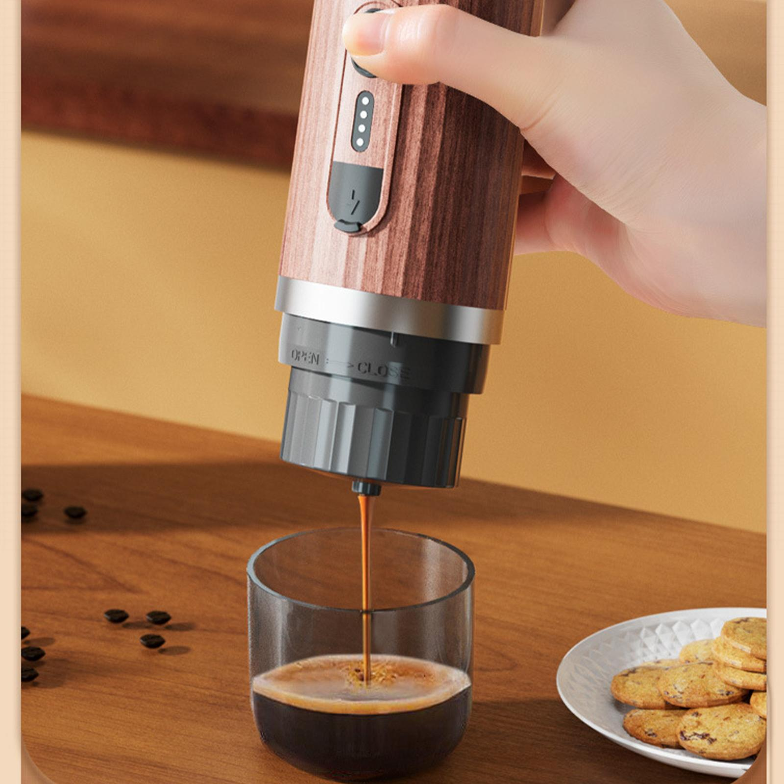 Hand gießt Kaffee aus einer Espresso-Maschine in ein Glas, Kekse daneben.