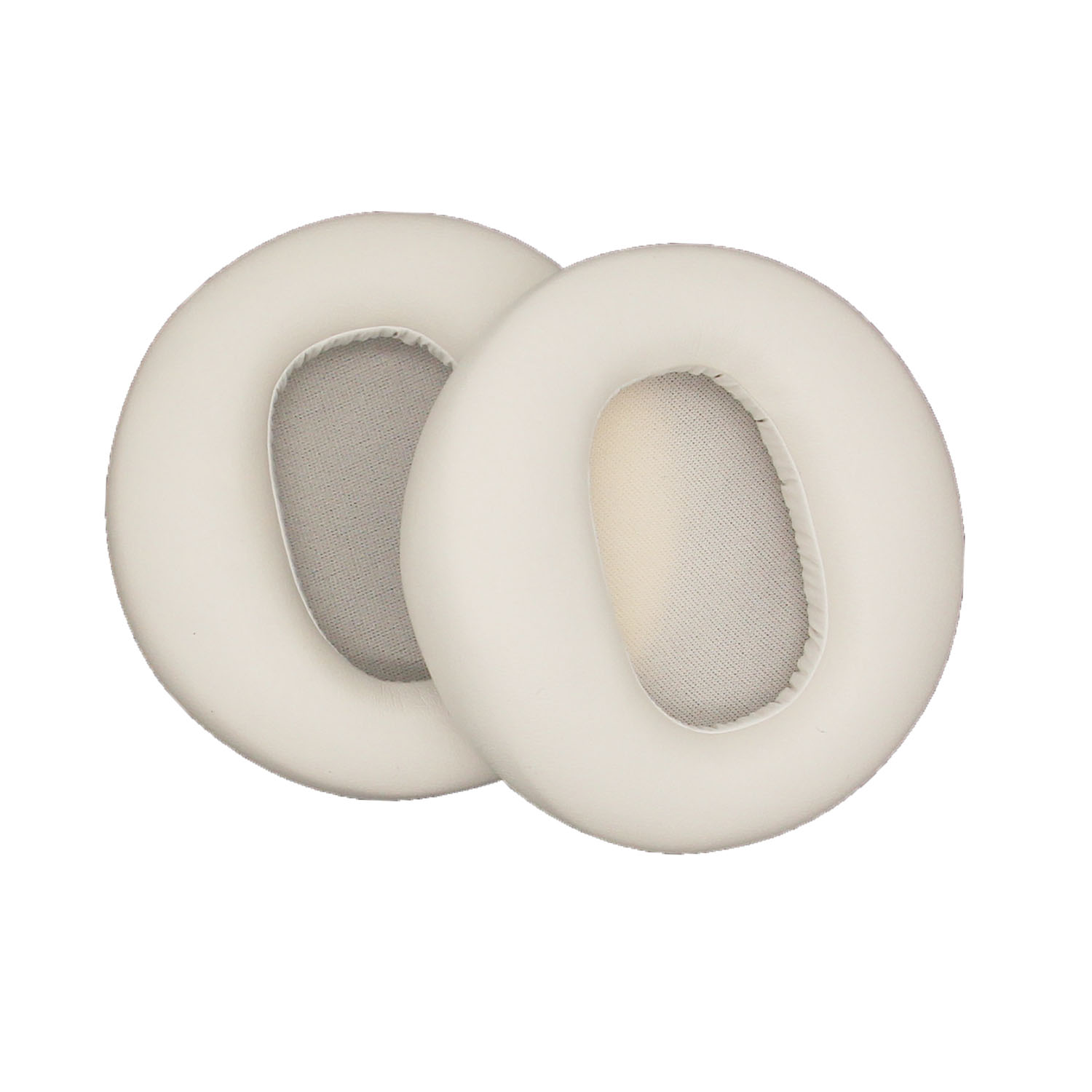 Vengono mostrati due cuscinetti auricolari bianco sporco per cuffie. Sono circolari con un'apertura ovale centrale.
