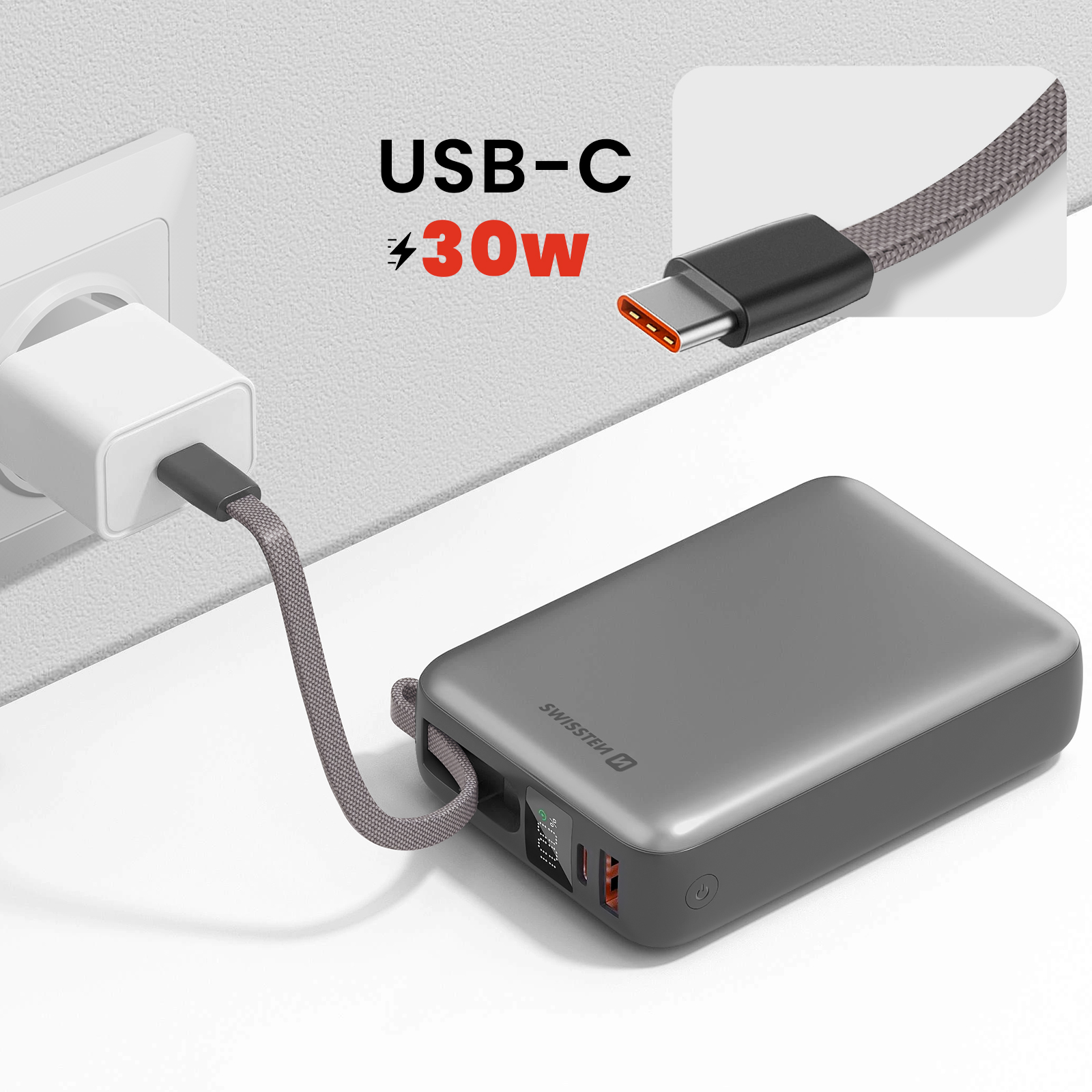 Graue Powerbank mit USB-C-Kabel, das an ein Wandladegerät angeschlossen ist. Text USB-C und 30W.