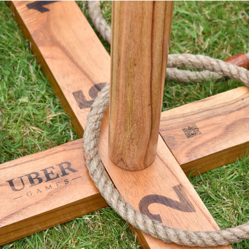 Seilringspiel. Ein Seilring um einen Holzpflock. Grüner Gras-Hintergrund.