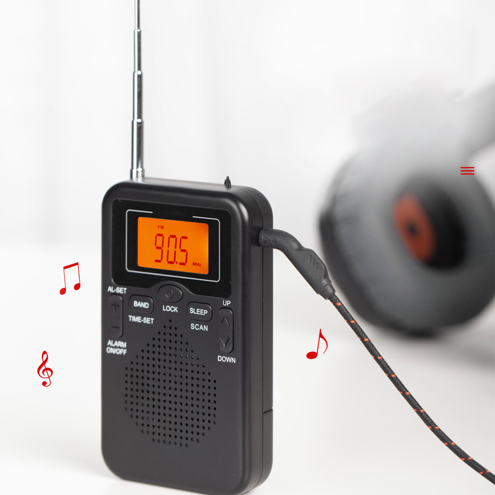 Schwarzes Radio mit orangefarbener Anzeige 90,5 MHz, mit schwarzem Kabel und Kopfhörern.