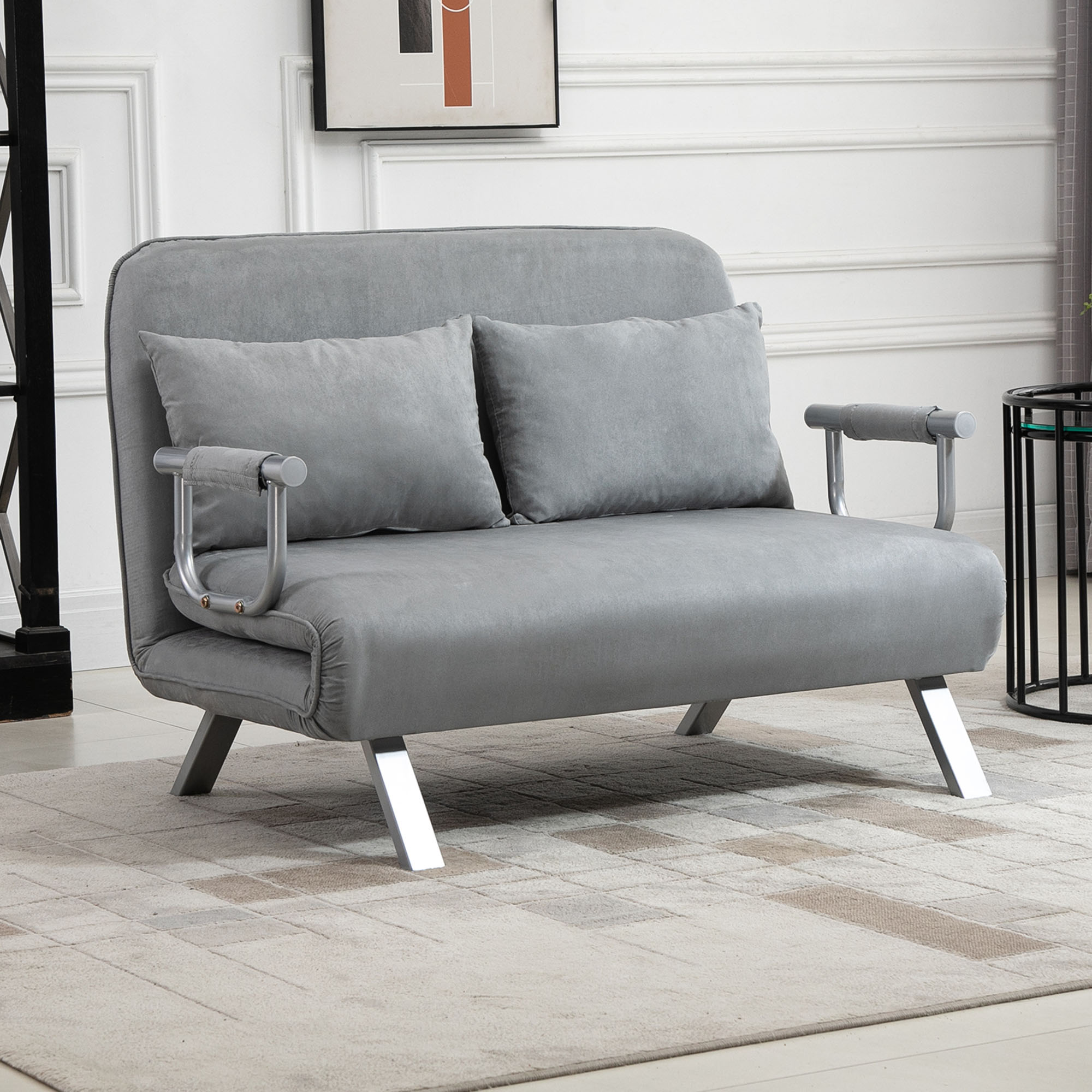 Graues Sofa mit zwei Kissen und silbernen Metallbeinen und Armlehnen auf einem Teppich.