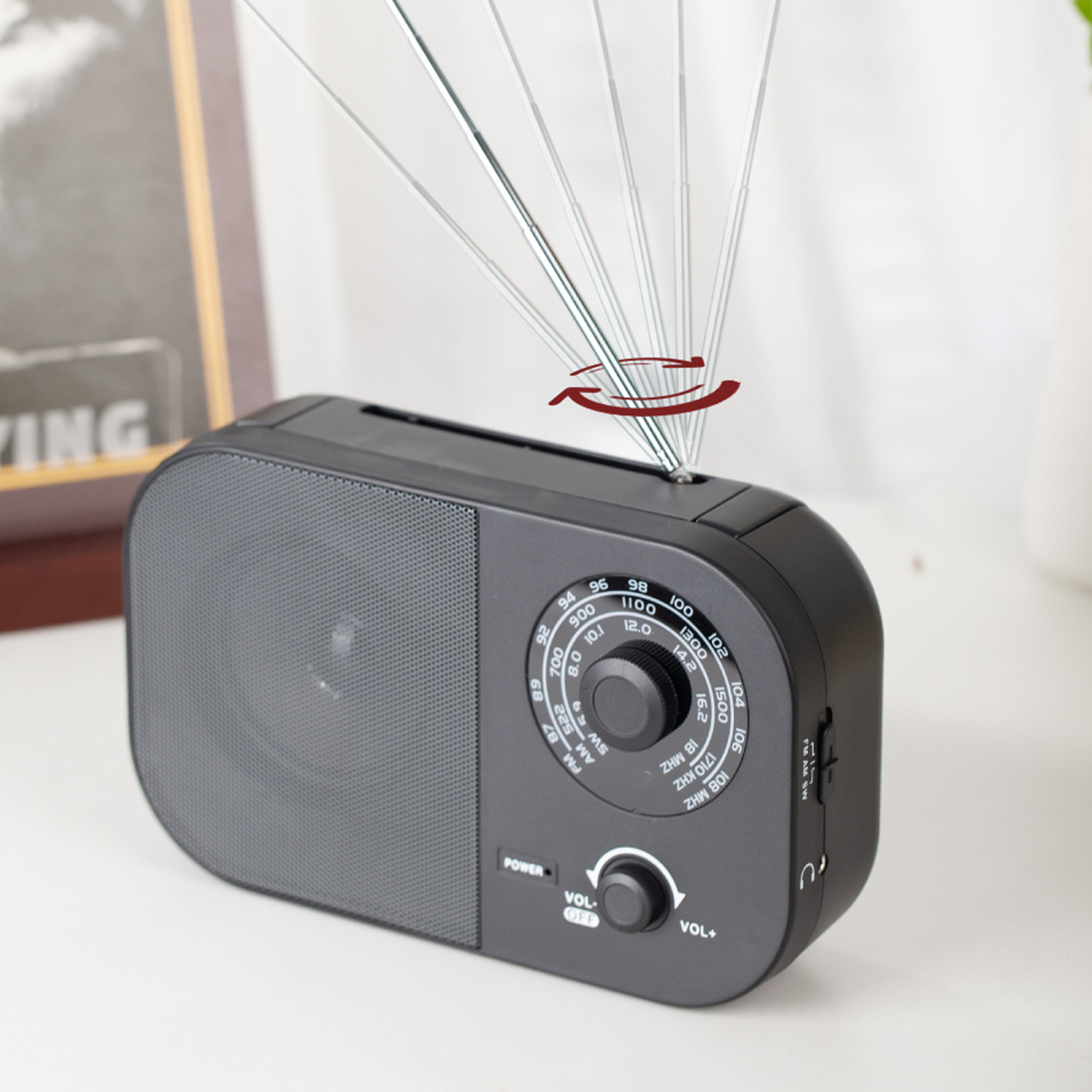 Ein schwarzes Radio mit Antenne und Bedienelementen. Die Antenne bewegt sich, als würde sie eingestellt.