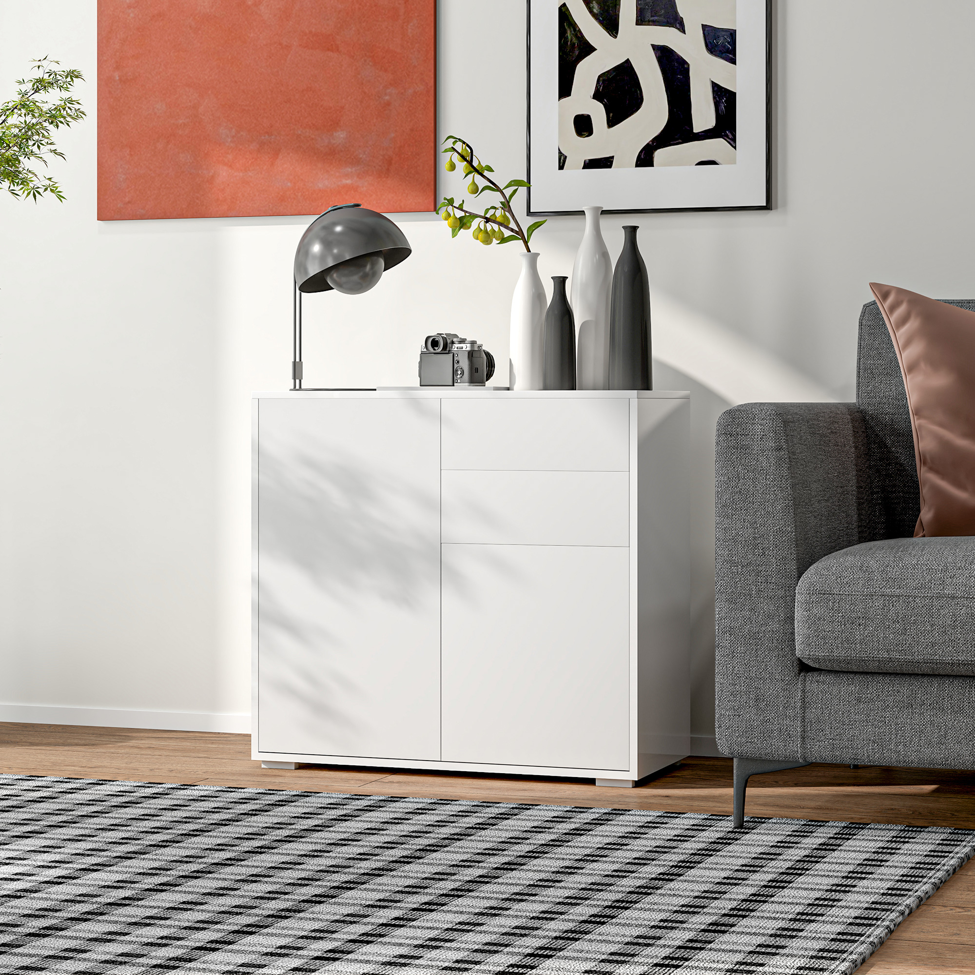 Weißer Schrank mit Deko, graues Sofa, Kunst, Teppich und Pflanze. Szene drinnen mit natürlichem Licht.
