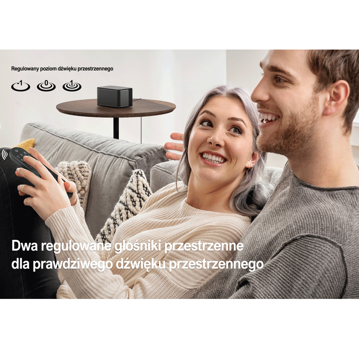 Para na kanapie, wchodząca w interakcję z pilotem i głośnikami, z tekstem.