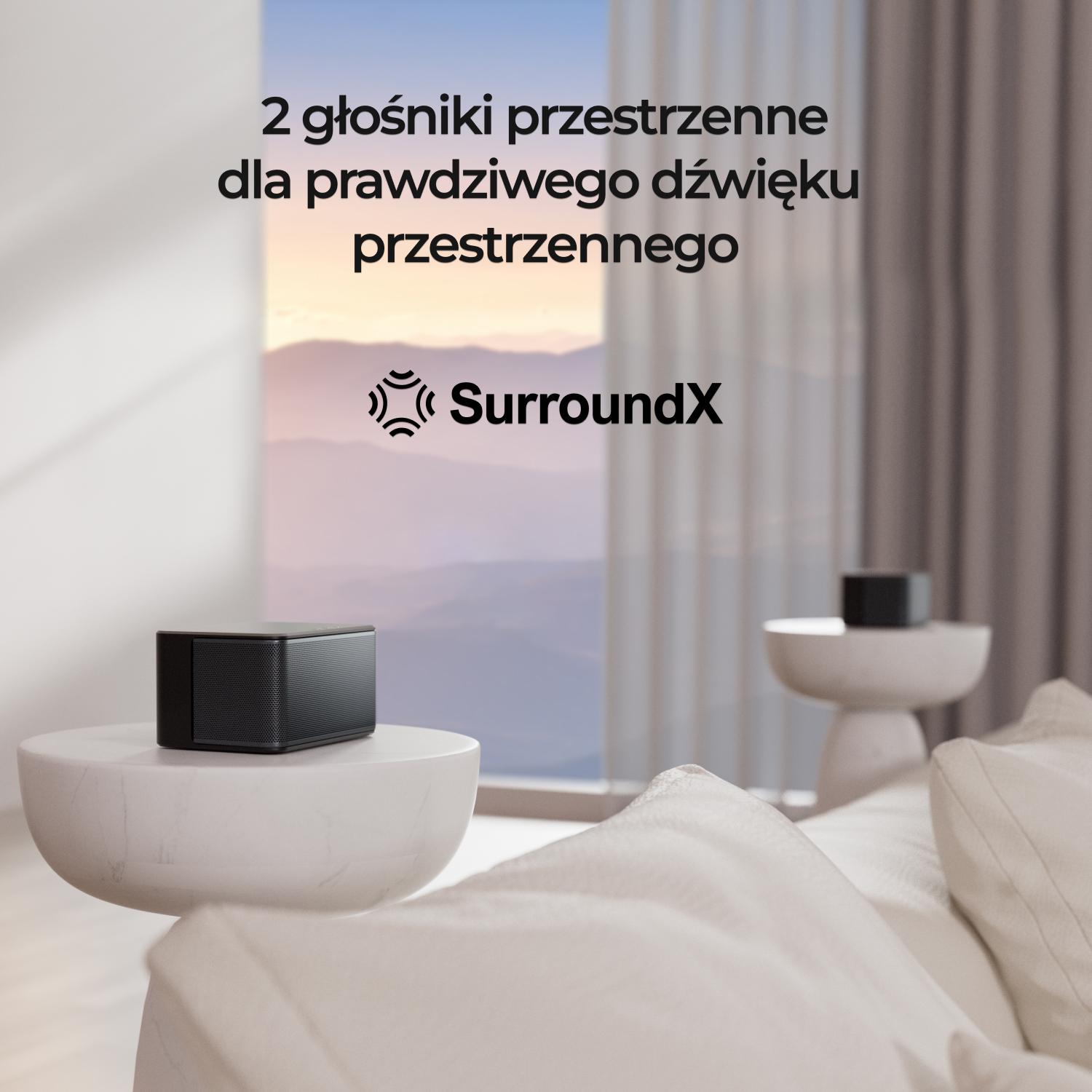 Czarny głośnik na białym stole. Widoczna biała sofa i malowniczy widok przez okno.