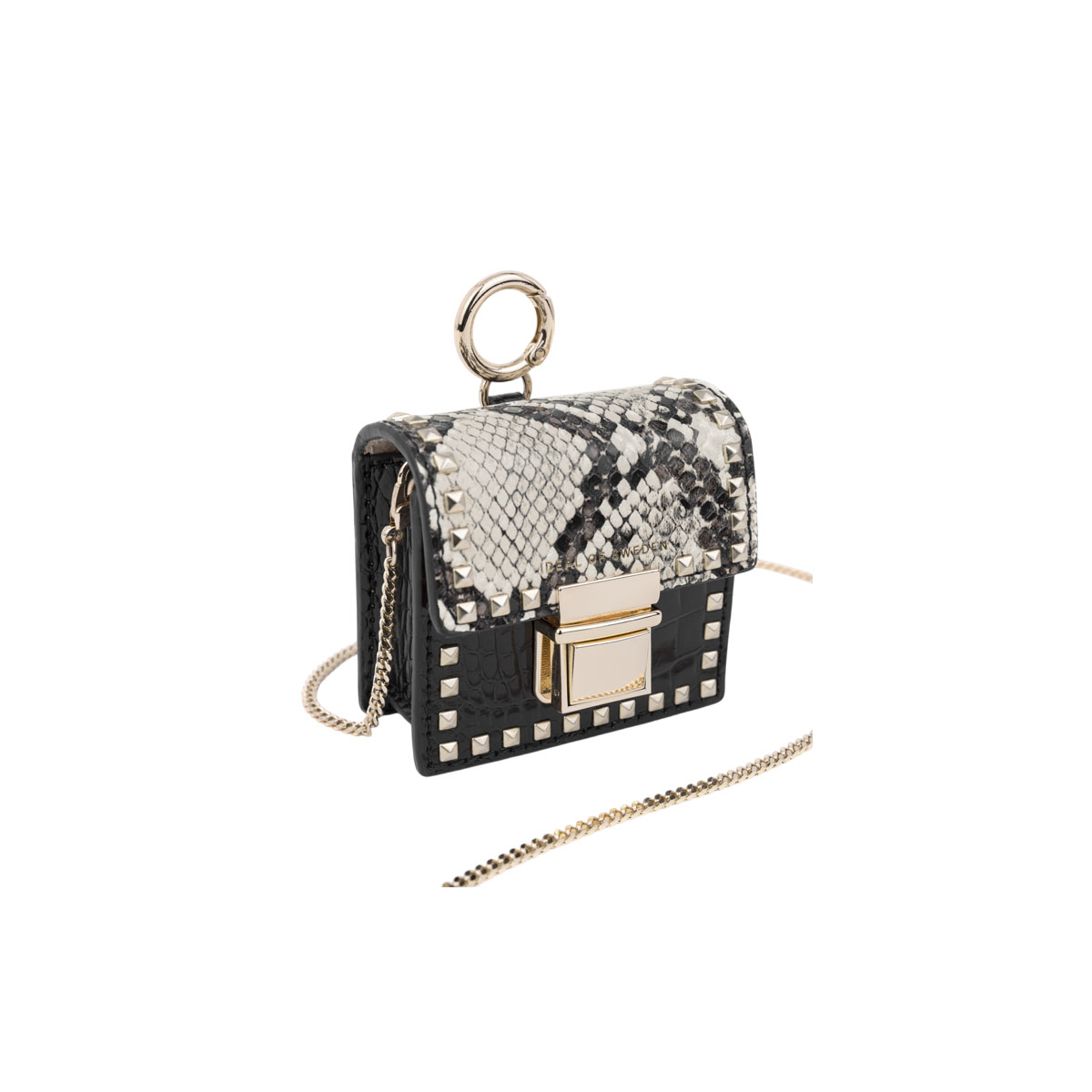 Bolso negro y de piel de serpiente, cadena dorada, cierre dorado, tachuelas doradas, fondo blanco.